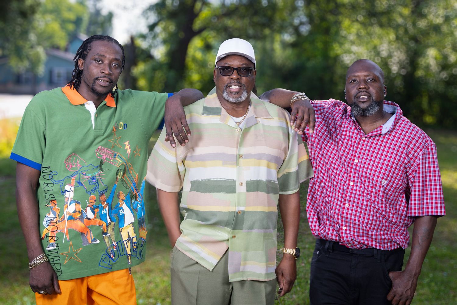 Three friends in casual summer attire pose together outdoors. Portrava Creative Studios