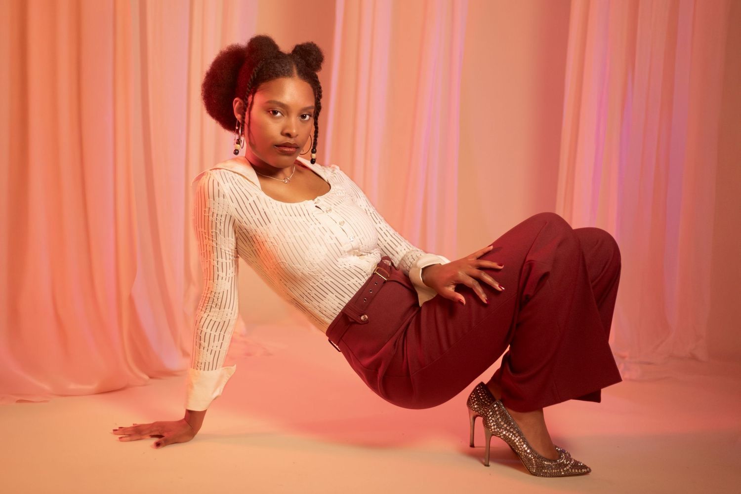 Fashion portrait with lace top and burgundy pants in soft pink studio lighting. Portrava Creative Studios