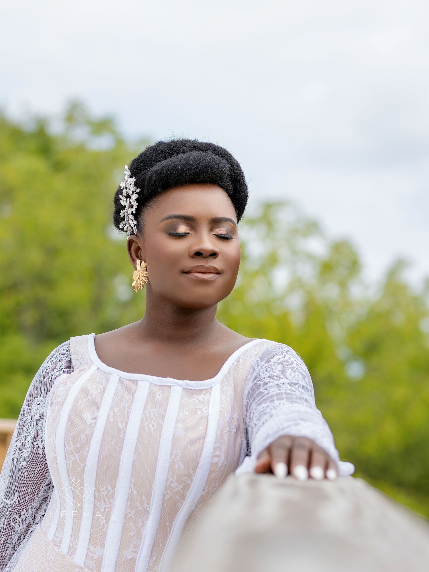 Serene bridal portrait featuring a white lace dress and elegant hair accessories.