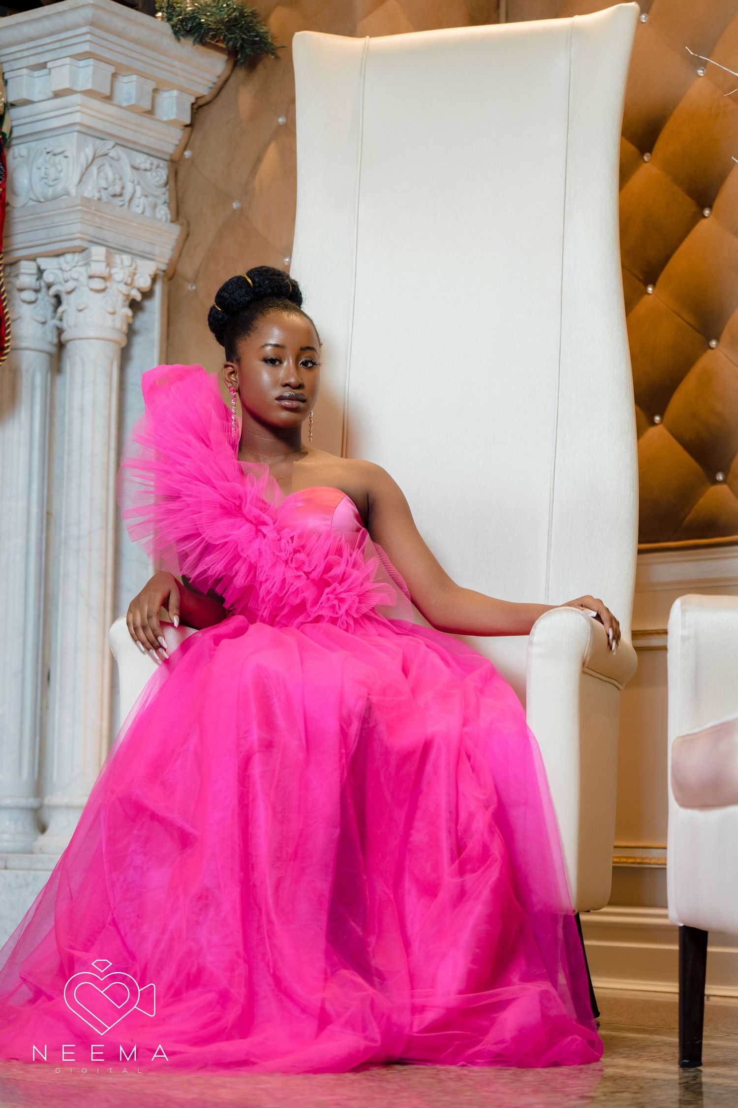 Glamorous fuchsia ballgown with ruffle detail photographed in an elegant interior setting.