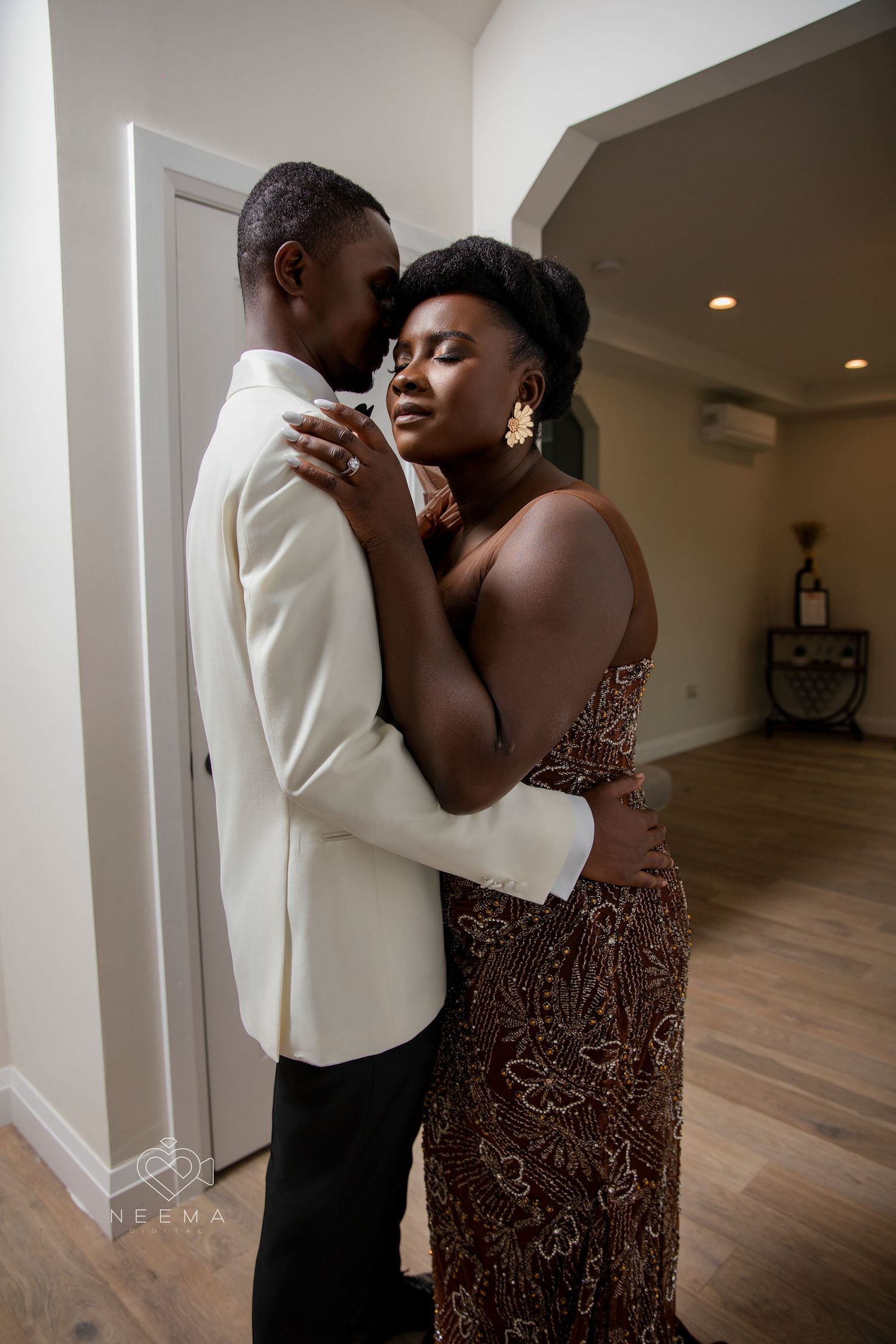 Intimate moment between couple in formal wear inside elegant interior setting.