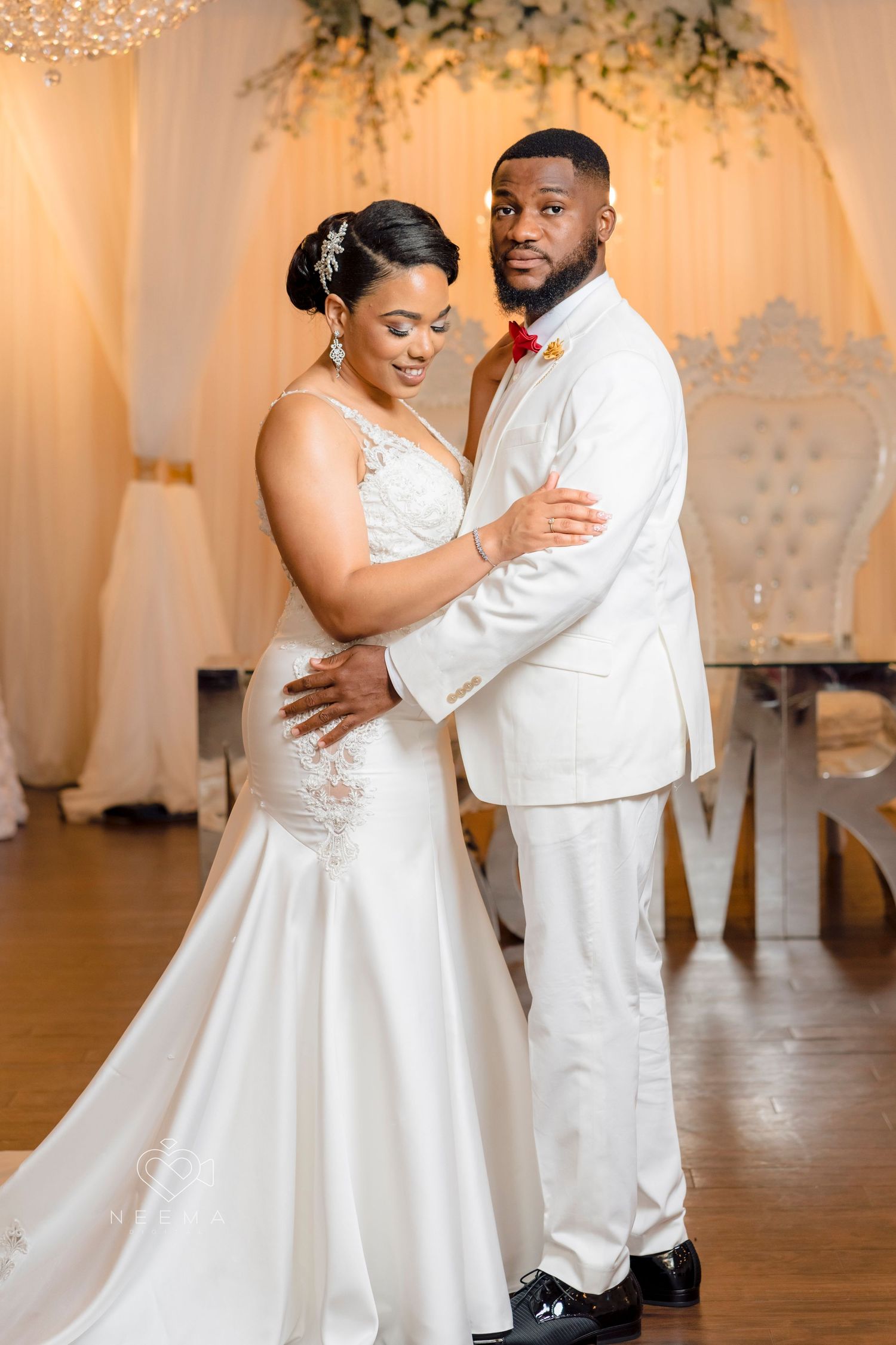 A tender moment between newlyweds during their first dance in an elegantly decorated venue.