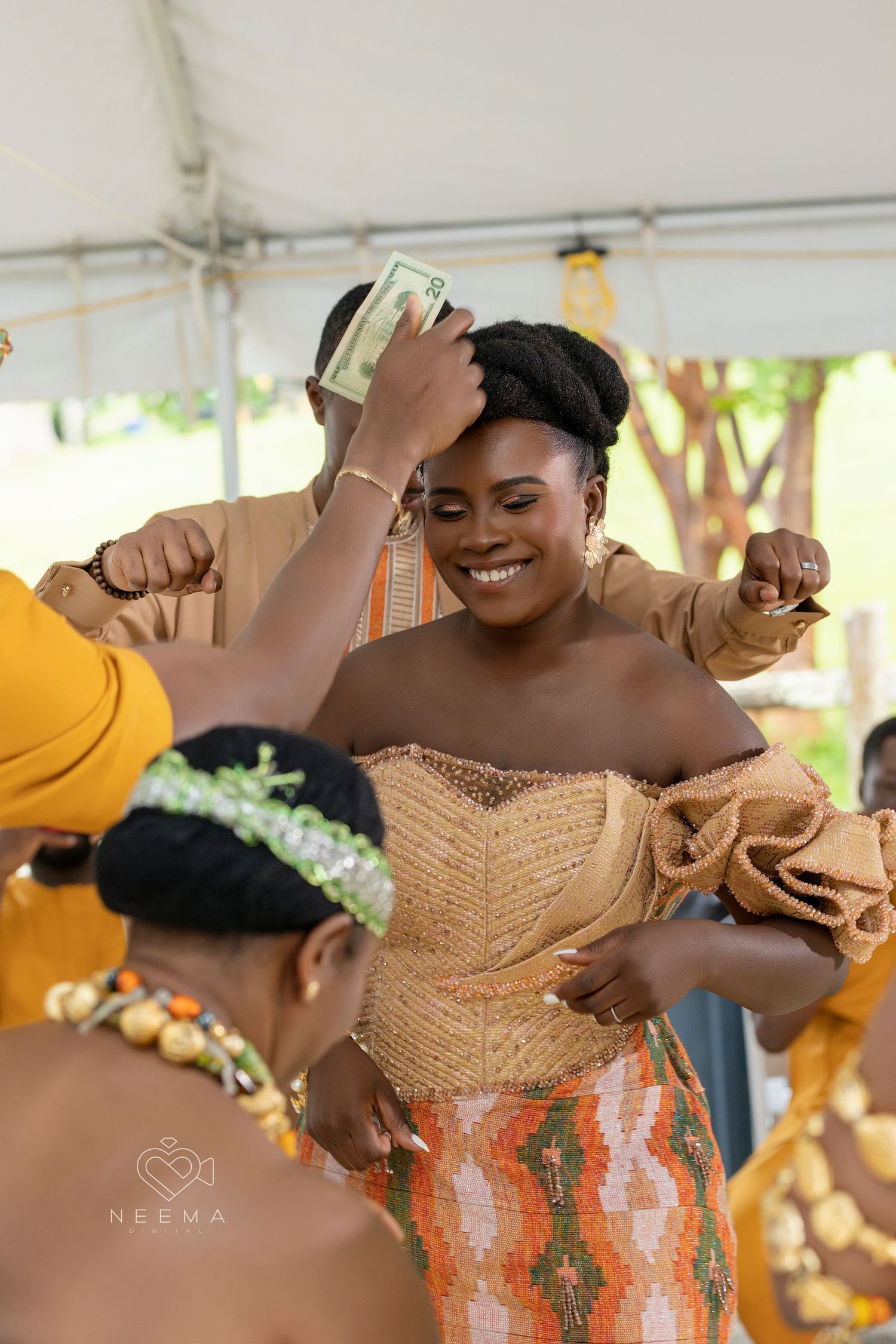 Dancing and celebration at an outdoor wedding reception under a white tent.