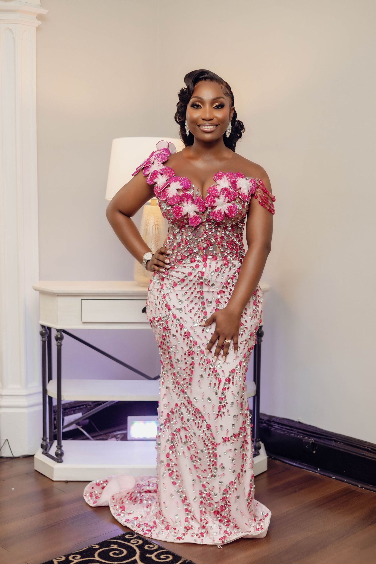 Beautiful off-shoulder pink floral wedding gown with beaded details and fitted silhouette.