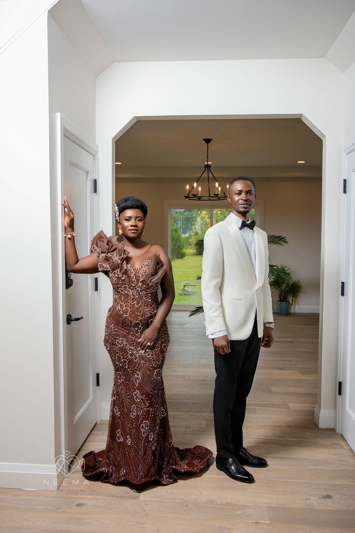 Formal portrait of a couple in evening attire featuring a sparkly bronze gown and white tuxedo jacket.