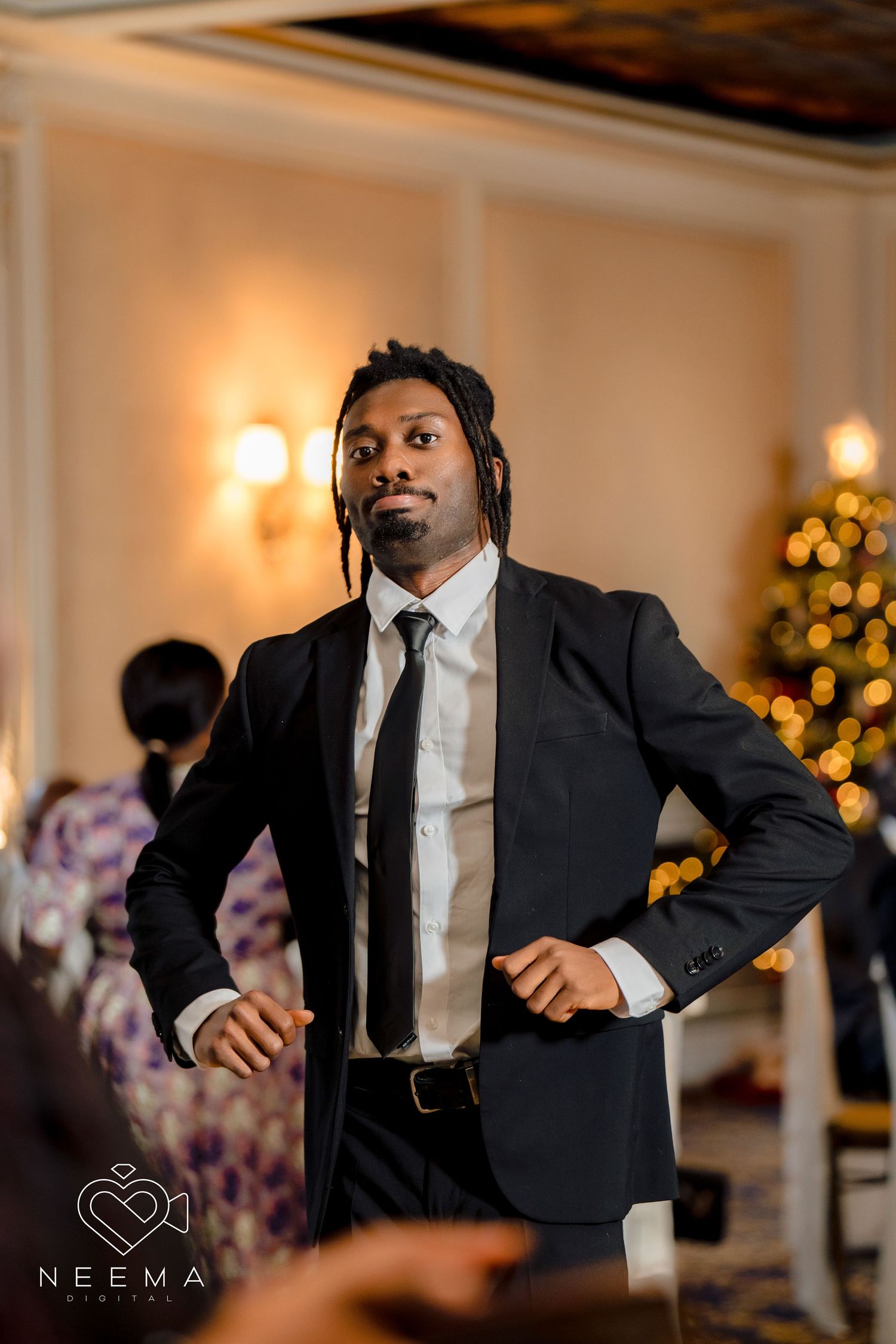 Stylish formal attire at an evening event with Christmas decorations in background.