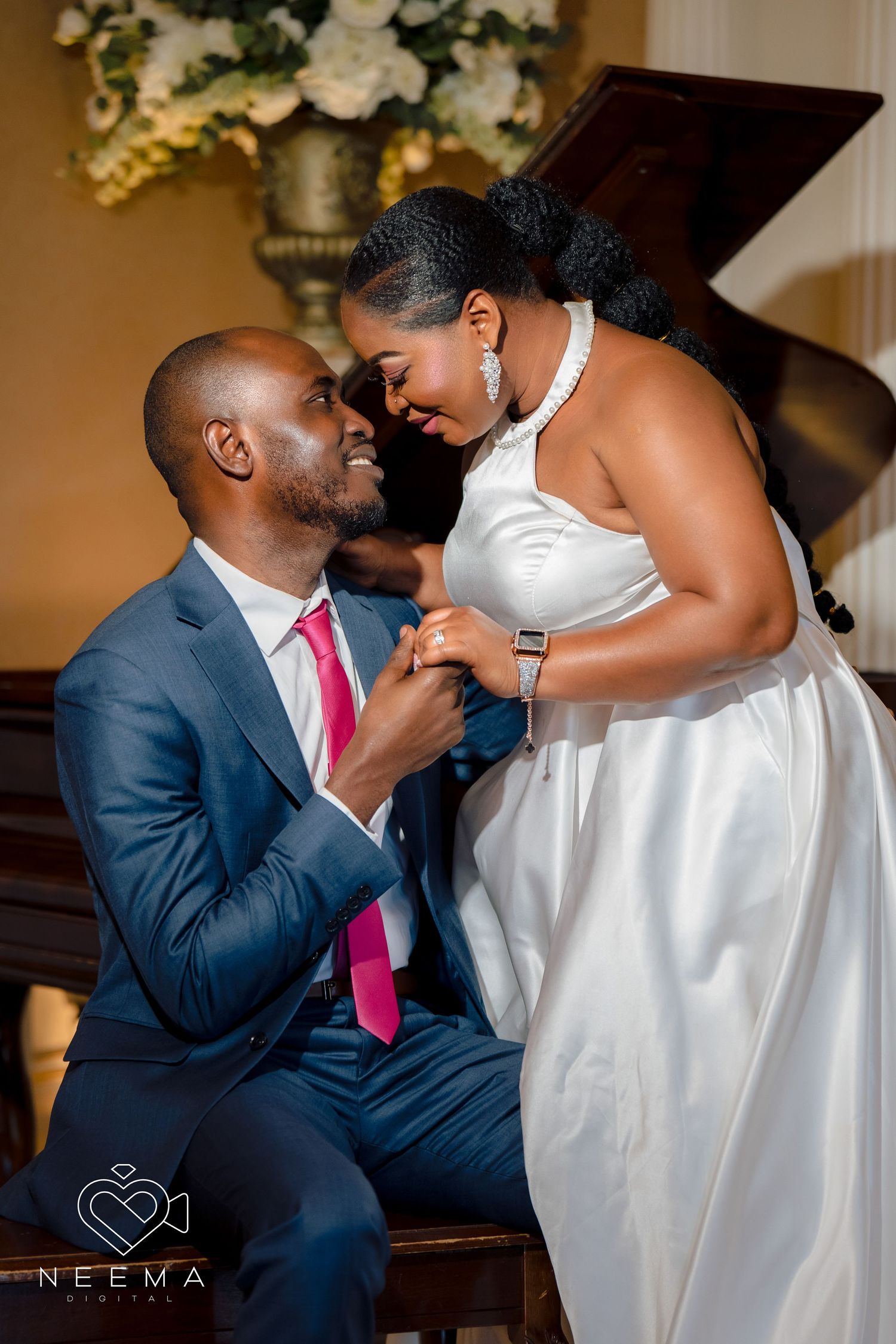 Romantic wedding moment captured by piano with white dress and blue suit.