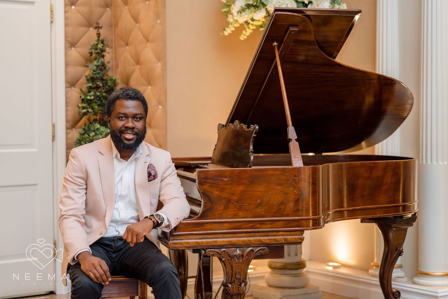 Elegant musician seated at a grand piano in a formal setting with holiday decor.