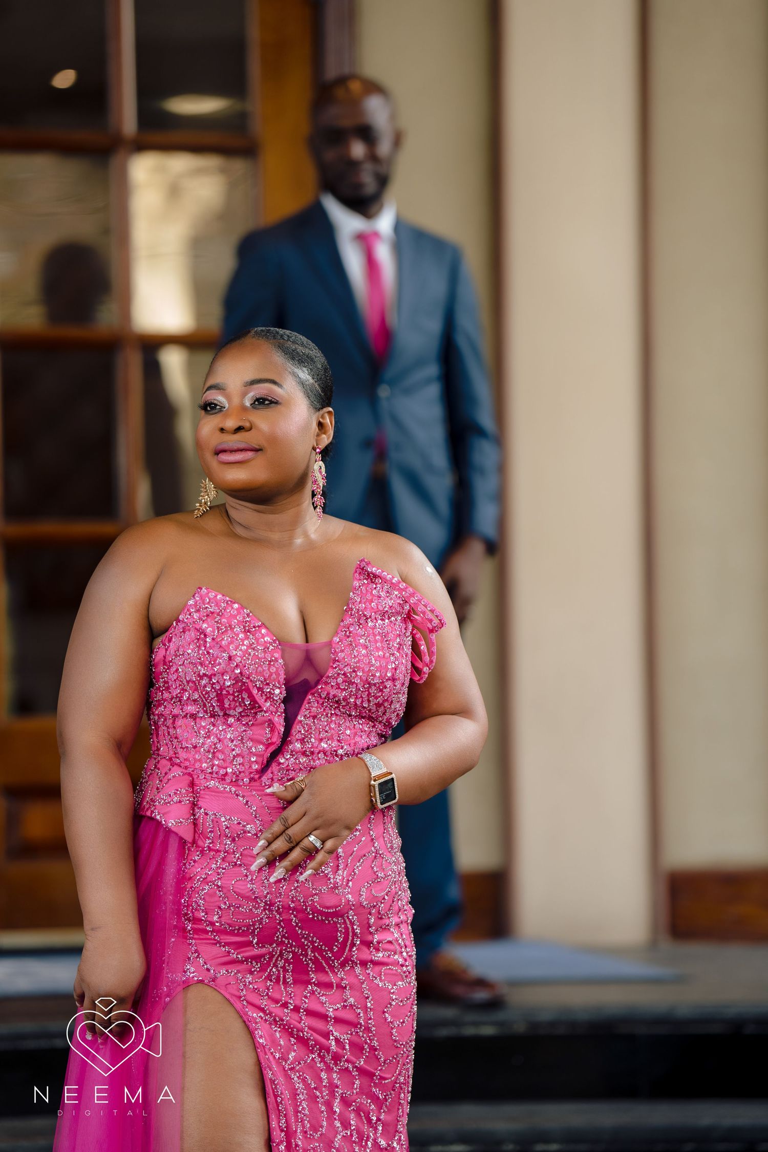 Elegant couple poses on building steps in formal evening wear.