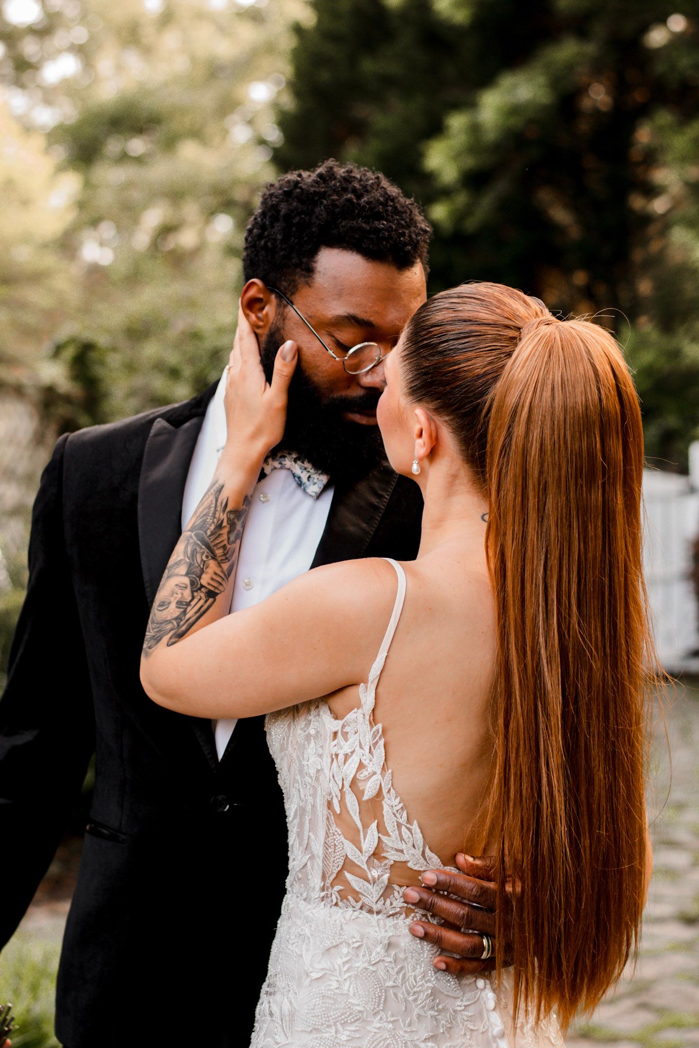 Romantic wedding couple shares an intimate moment with the bride in lace and groom in black tuxedo Wildflower 301 Venue in Greensboro, GA