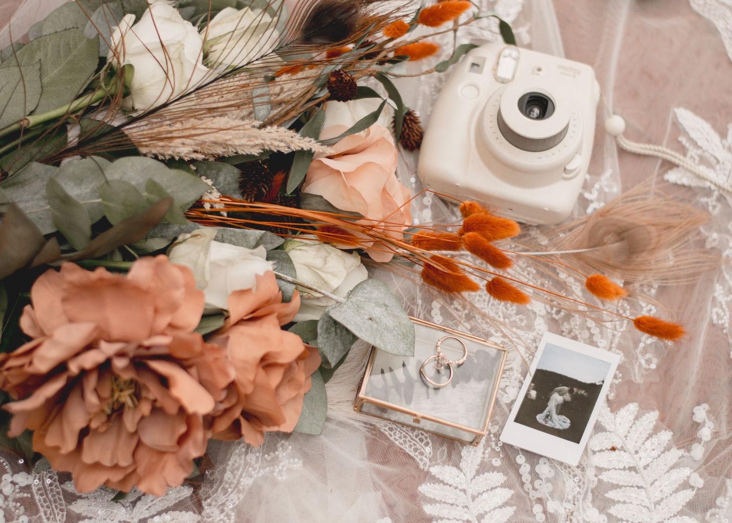 Flatlay of vintage camera, film, peach rose, eucalyptus leaves and dried flowers on lace backdrop at Providence Canyon in Lumpkin, Georgia