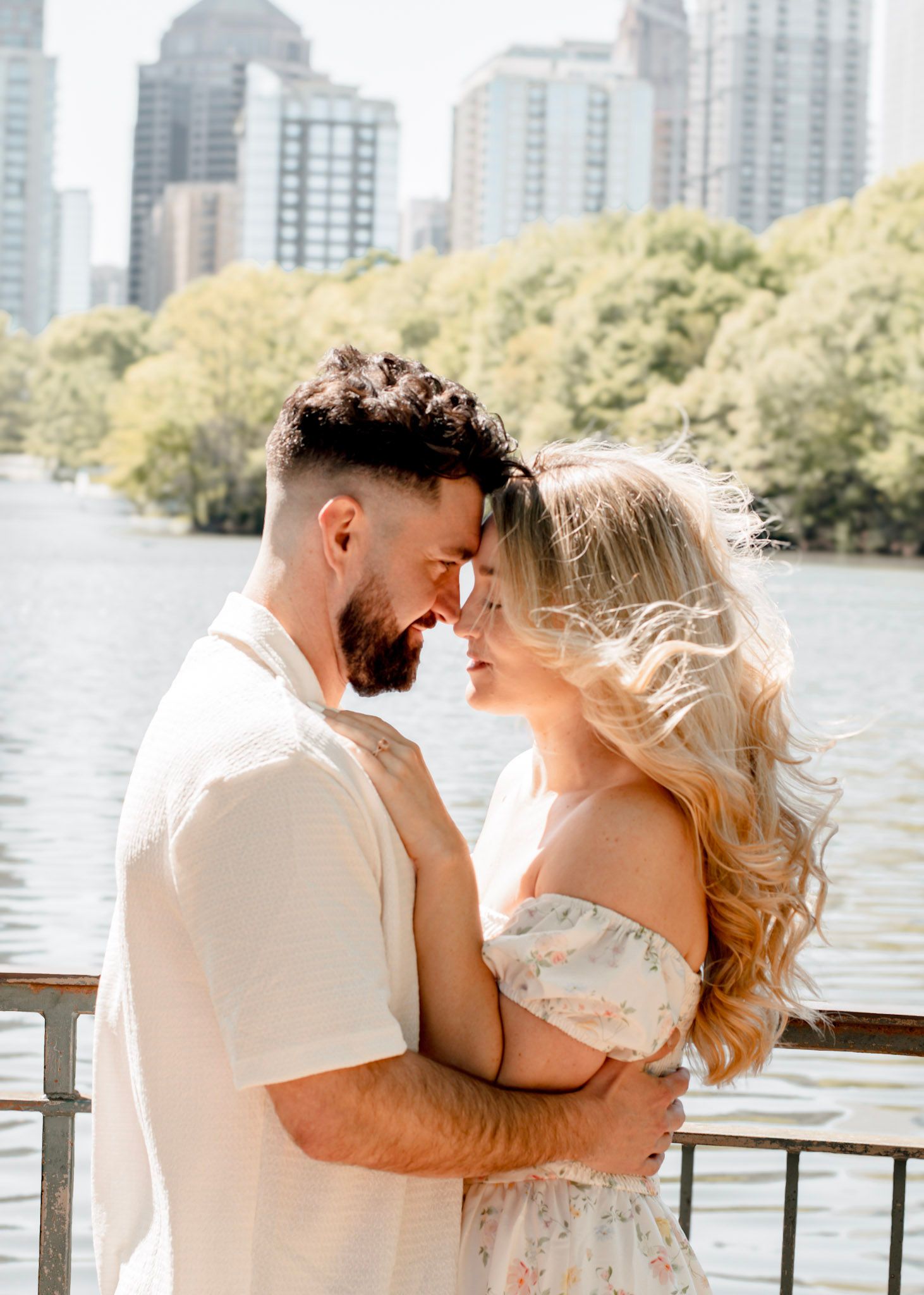 A romantic couple at an engagement session along a wooded path at Piedmont park in warm sunlit nature setting in Atlanta, Georgia