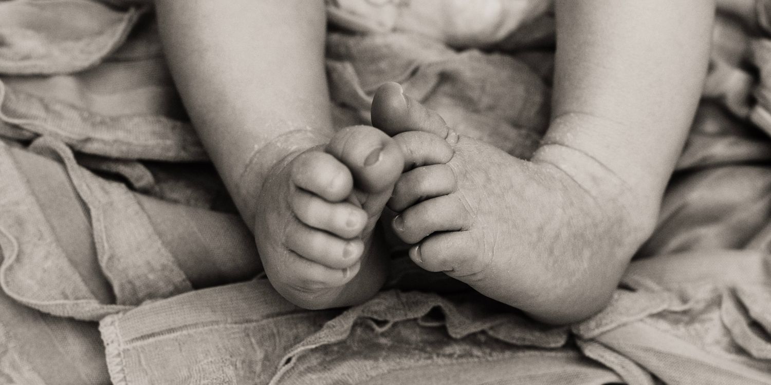 Close-up black and white photo showing  small baby feet in soft focus in Covington, Georgia