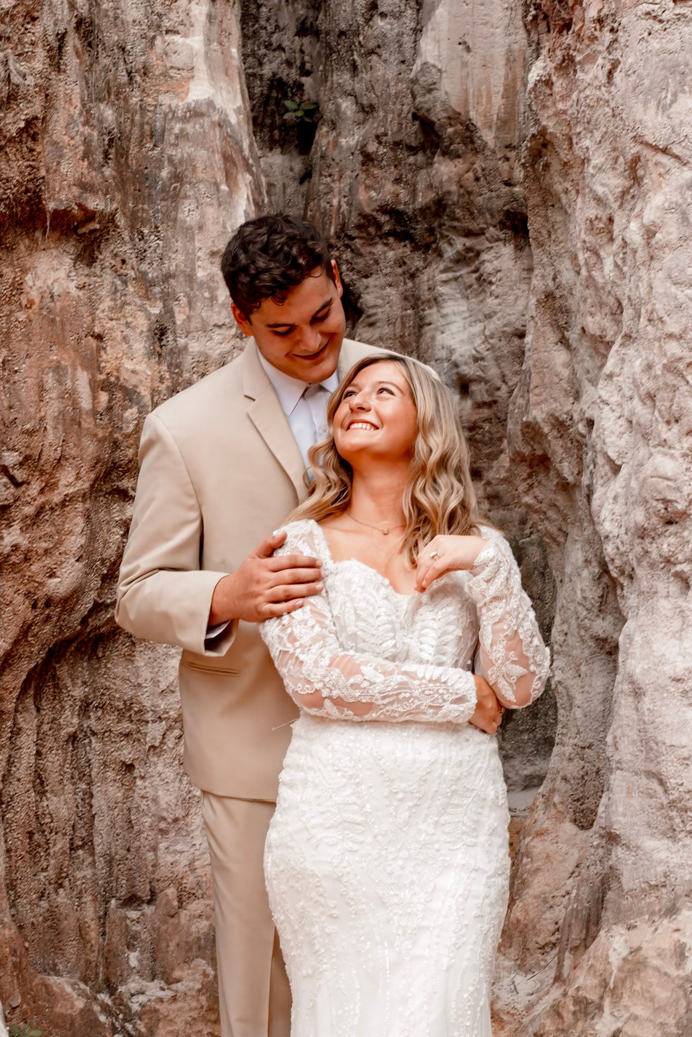 A romantic wedding photoshoot featuring a bride and groom embracing at Providence Canyon in Lumpkin, Georgia