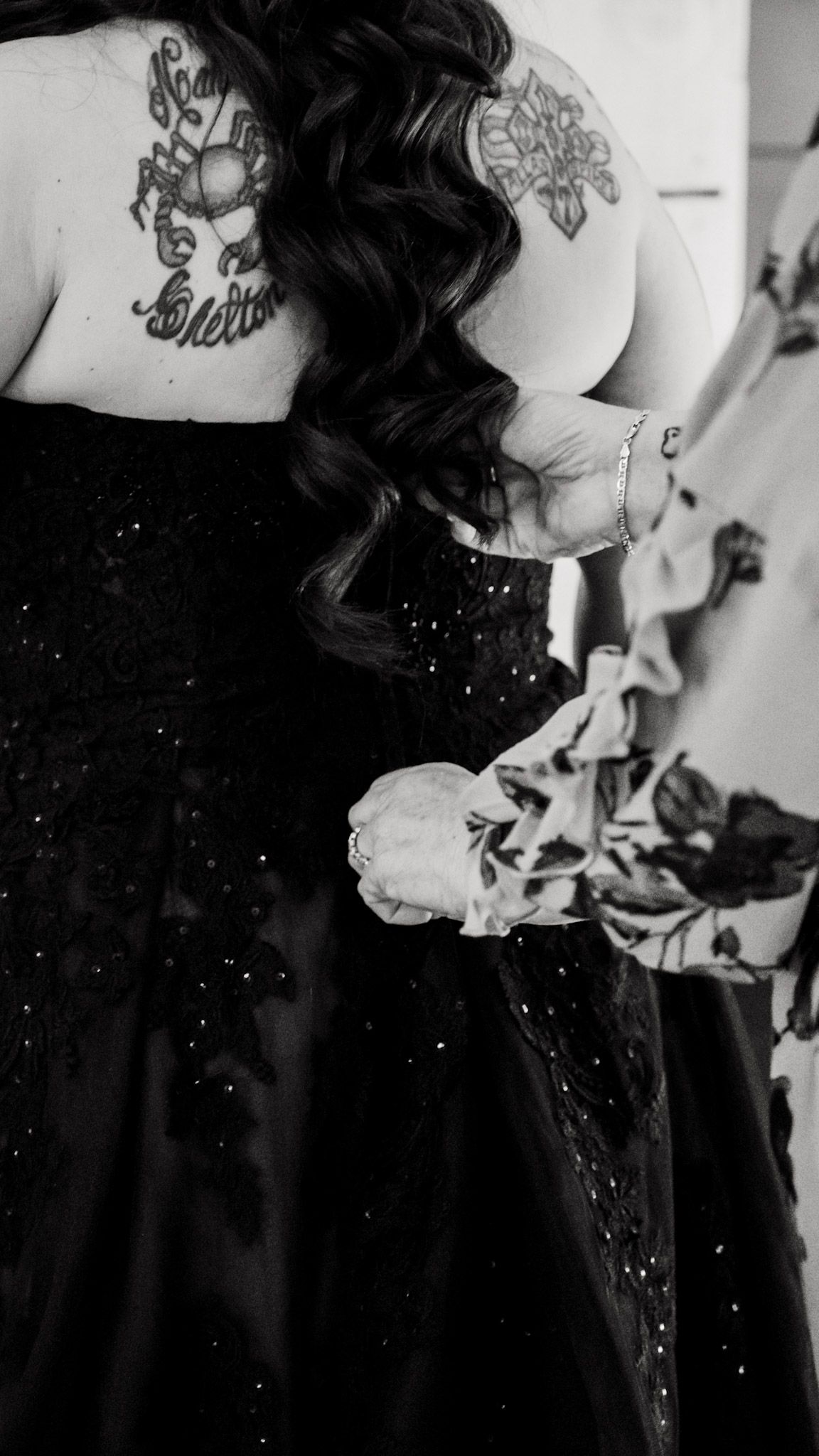A black and white bridal portrait of brides mother zipping brides dress at Koury Farms in  Auburn, Georgia.