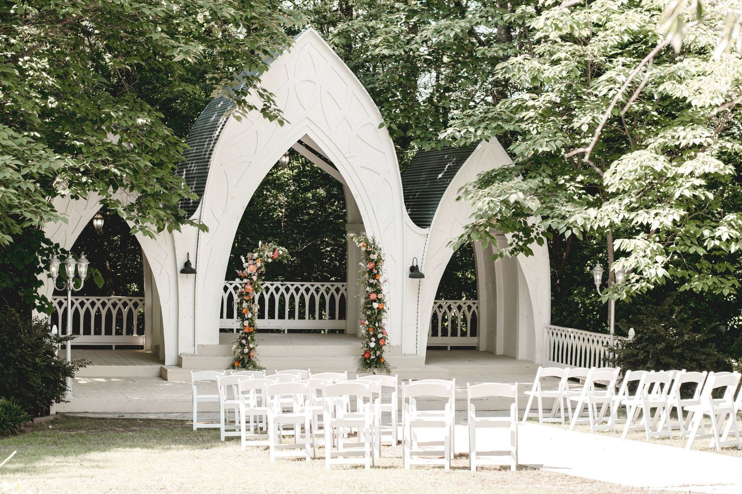 An elegant outdoor wedding ceremony setup with arched structures in a garden setting at Wildflower 301 Venue in Greensboro, Georgia