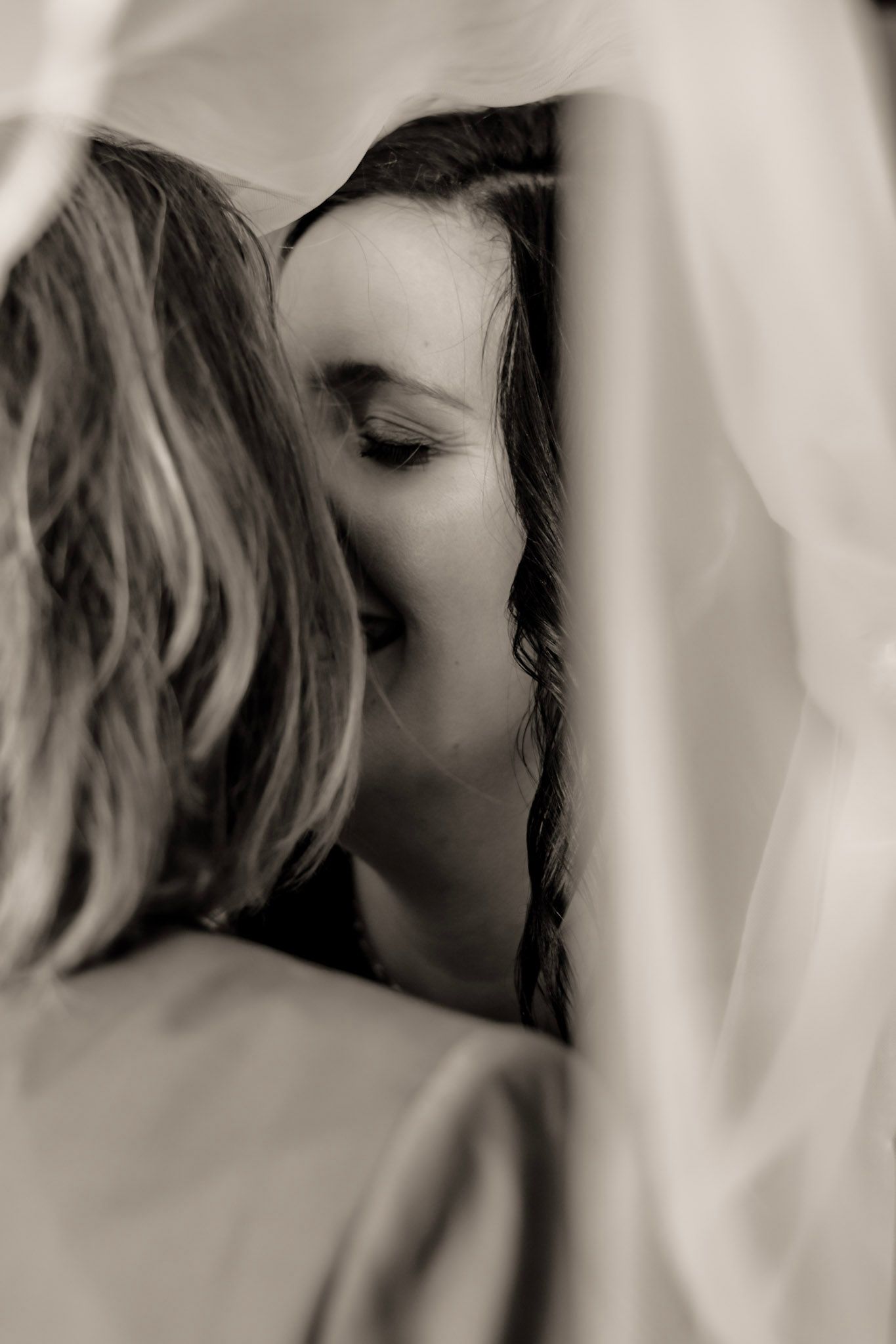 A soft black and white artistic photo series showing an intimate kiss between two brides in profile in Albany, Georgia.