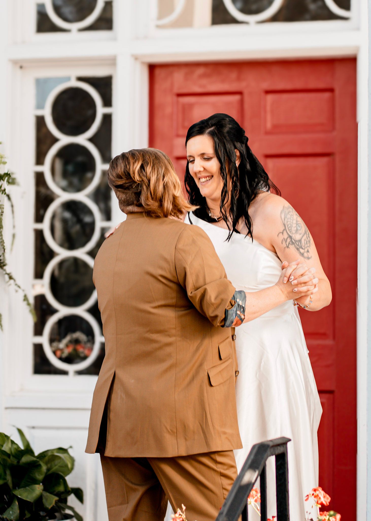 Newlywed brides shares a tender moment while embracing on steps in Albany, Georgia
