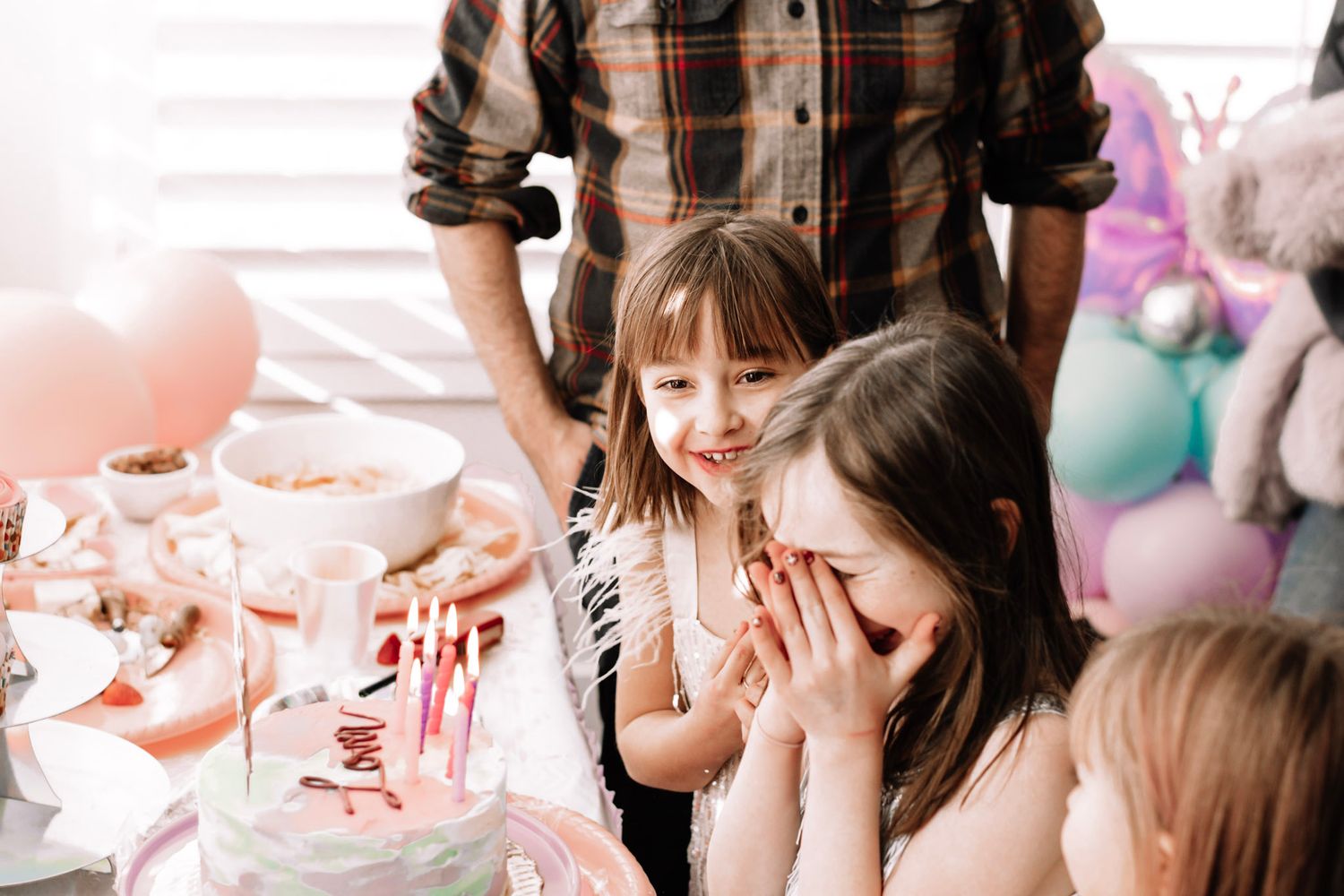 A pink and pastel-themed child's  birthday party celebration moments with cake, balloons, and joyful gatherings.