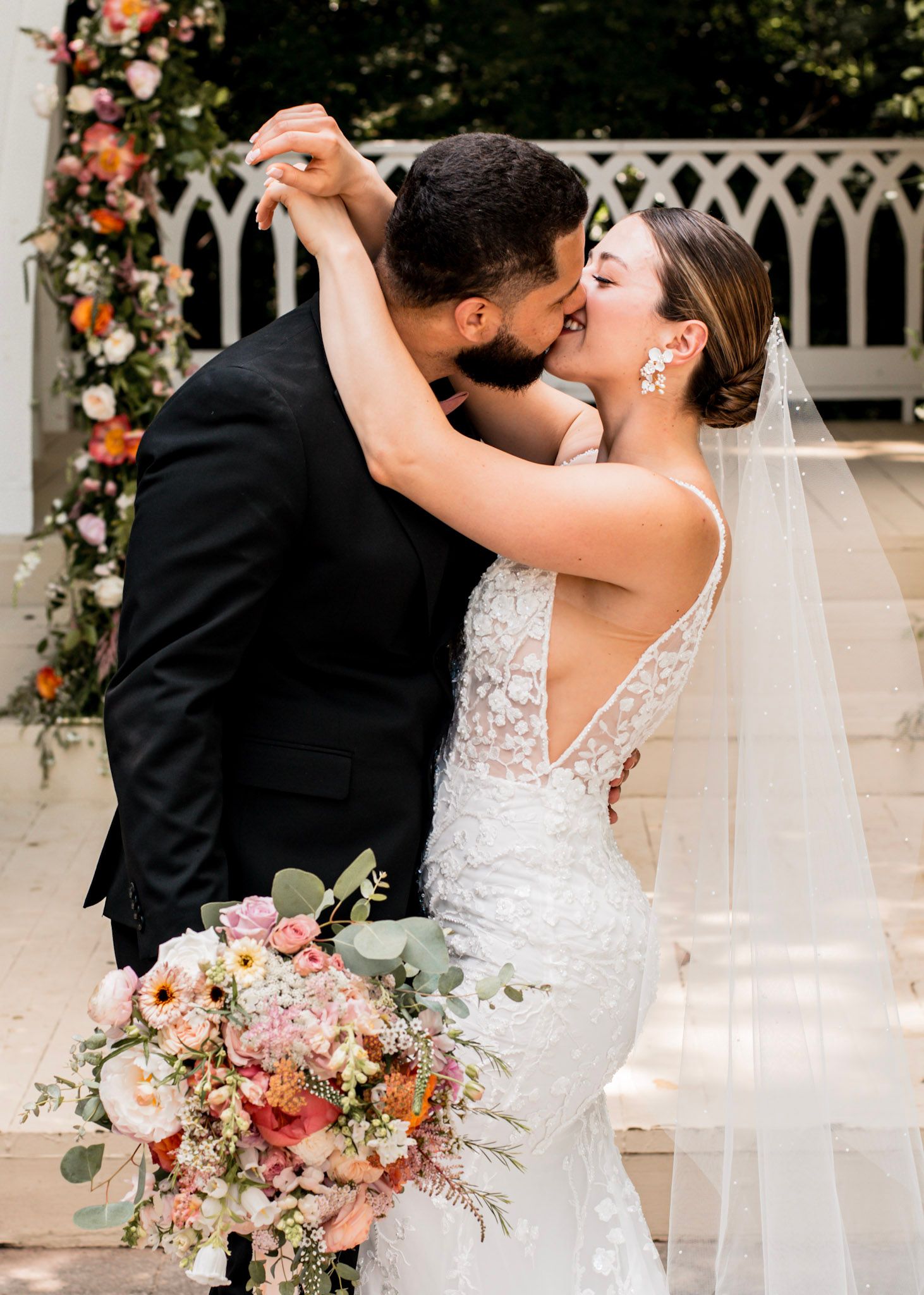A bride and groom share their first kiss during an outdoor wedding ceremony at The Wildflower 301 wedding Venue in Greensboro, Georgia
