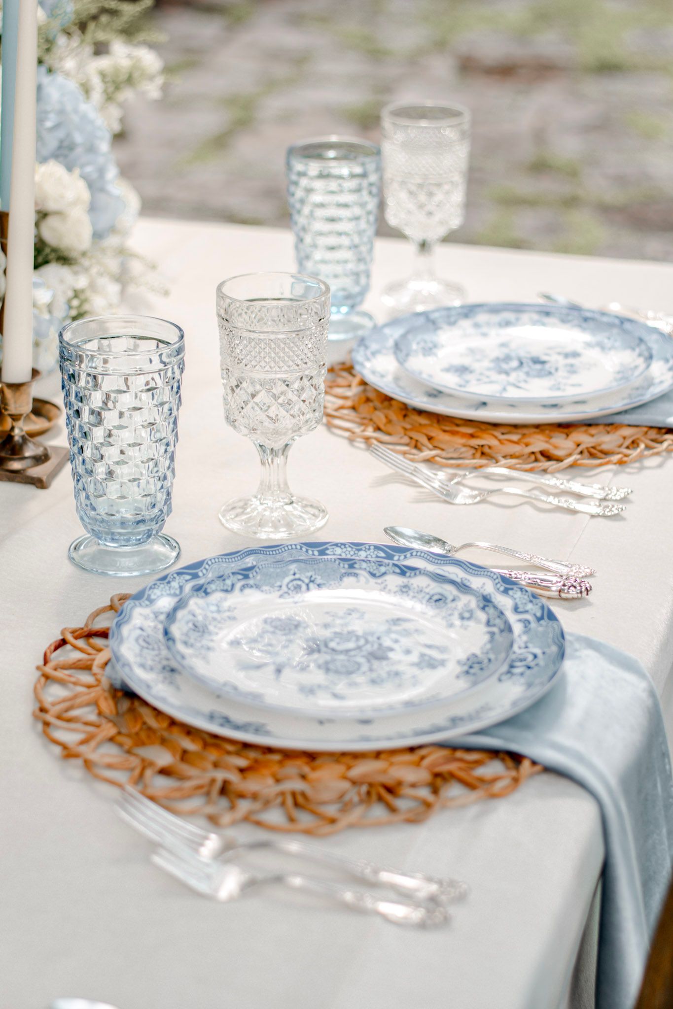 Elegant table setting with blue and white china plates and crystal glasses on a white tablecloth Wildflower 301 Venue in Greensboro, Georgia