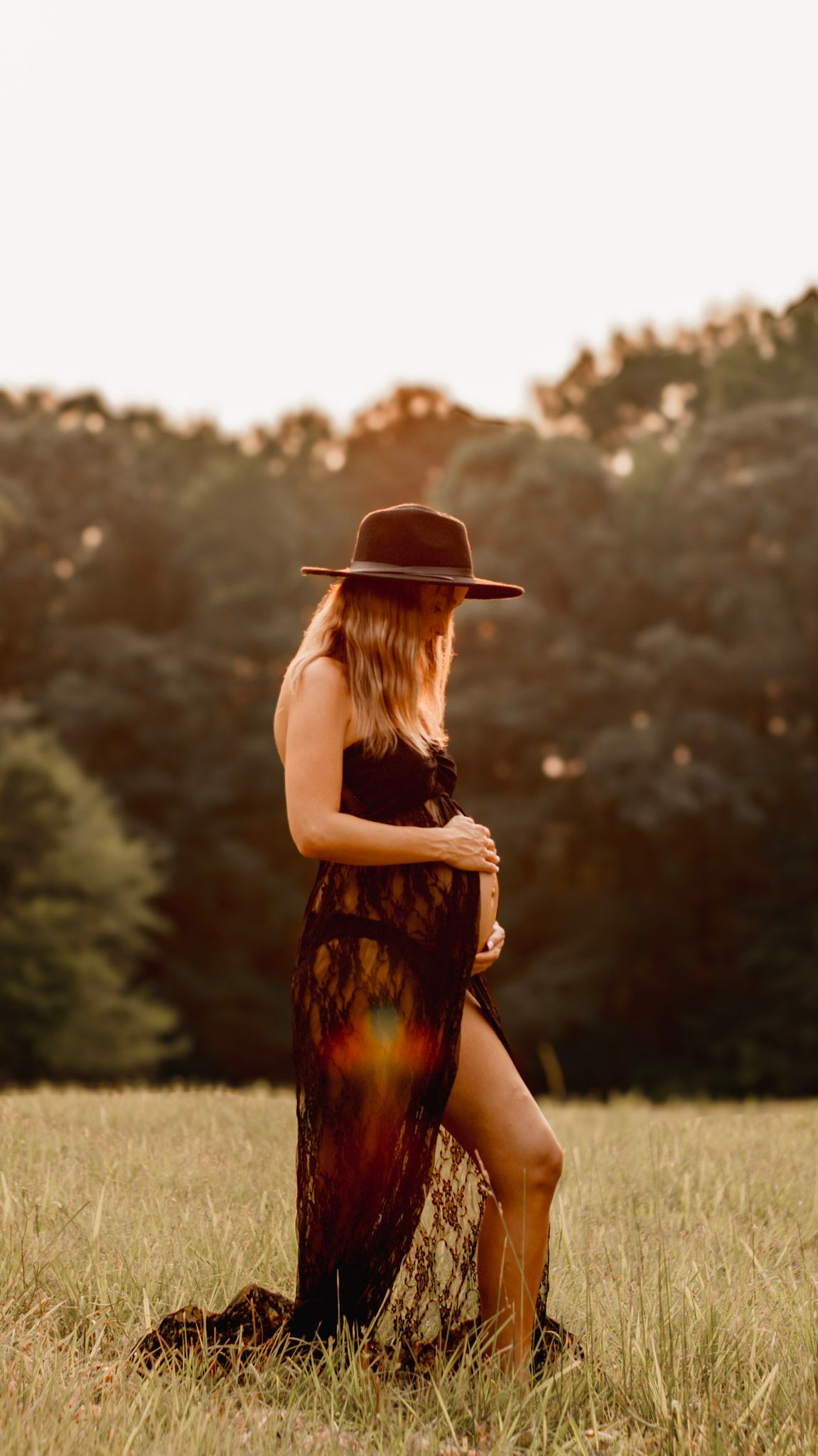 A mother in a sunlit meadow at golden hour, creating a dreamy summer atmosphere at Kennesaw Mountain in Kennesaw, Georgia