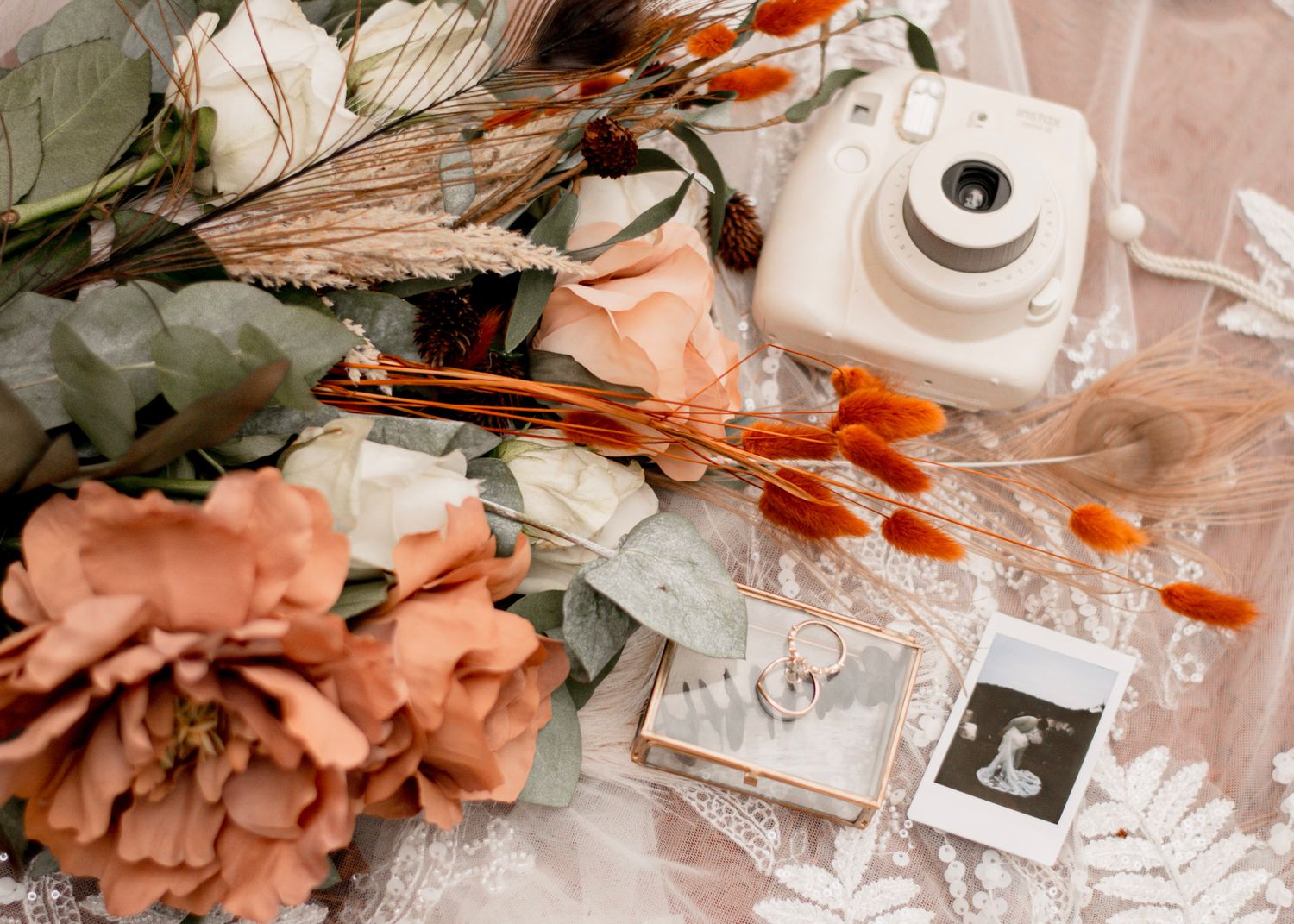 Wedding items including flowers, ribbons, and photos arranged on a lace at Providence Canyon in Lumpkin, Georgia.