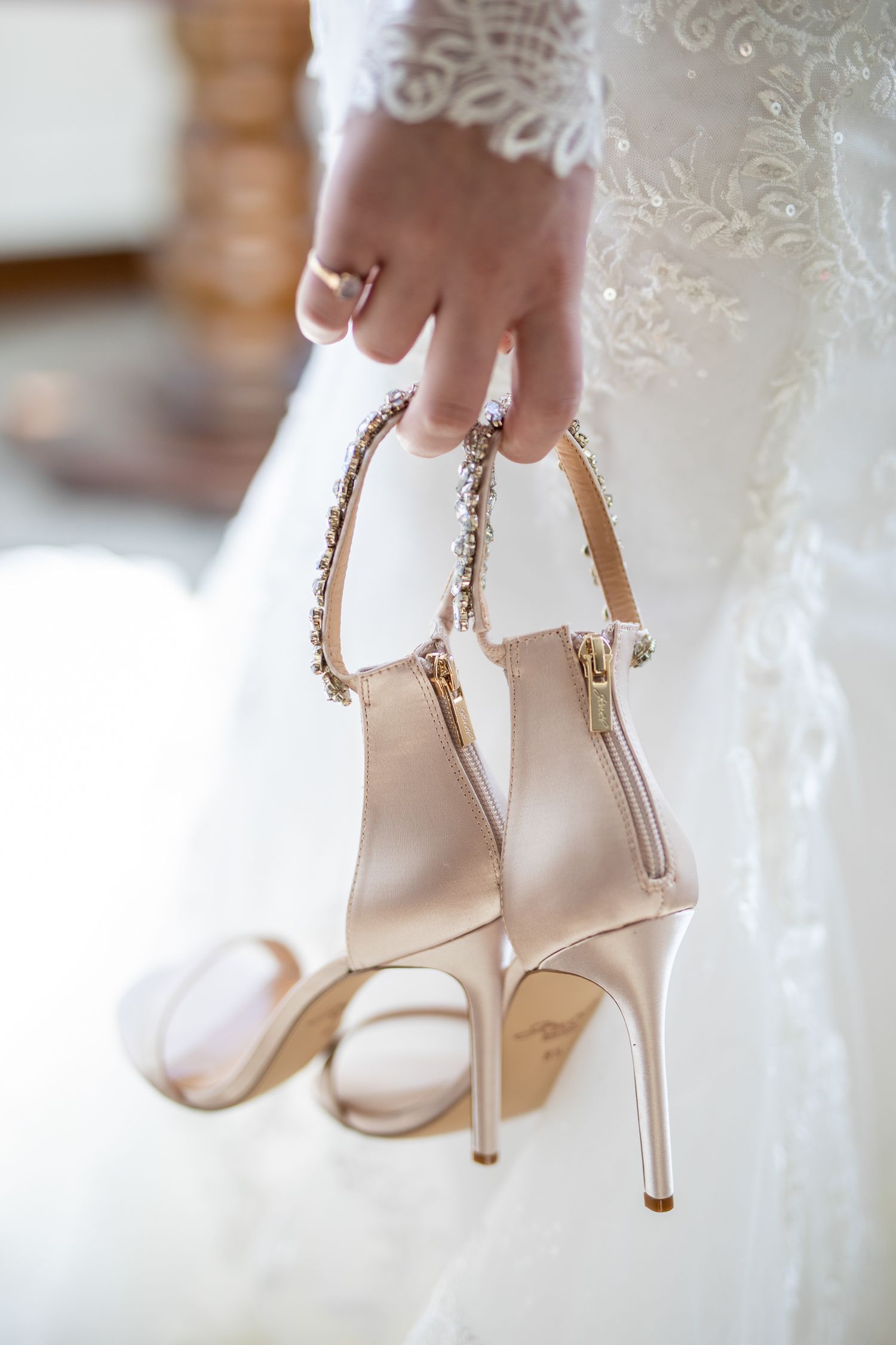Elegant white bridal heels with delicate ankle straps and metallic stiletto heels displayed against lace fabric Fairmont Banff Springs Hotel
