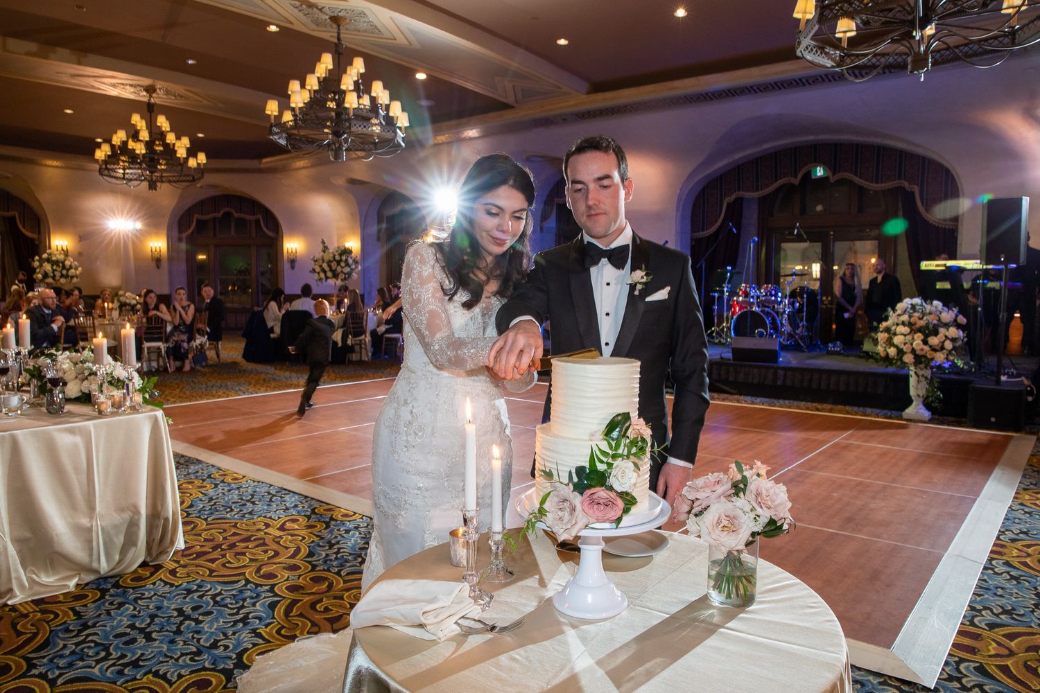 Wedding reception guests dancing and celebrating on a beautifully lit ballroom dance floor at an elegant venue at Fairmont Banff Springs.