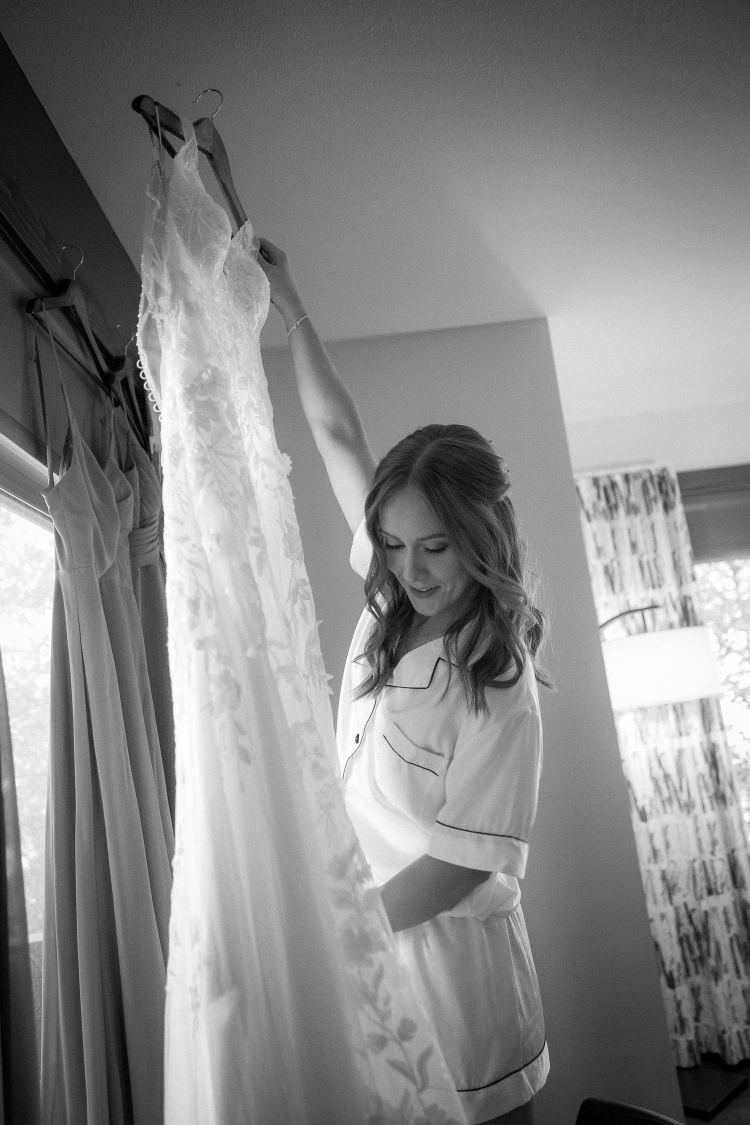 A series of black and white photos showing a person in a white shirt dancing and moving gracefully near curtained windows in Canmore