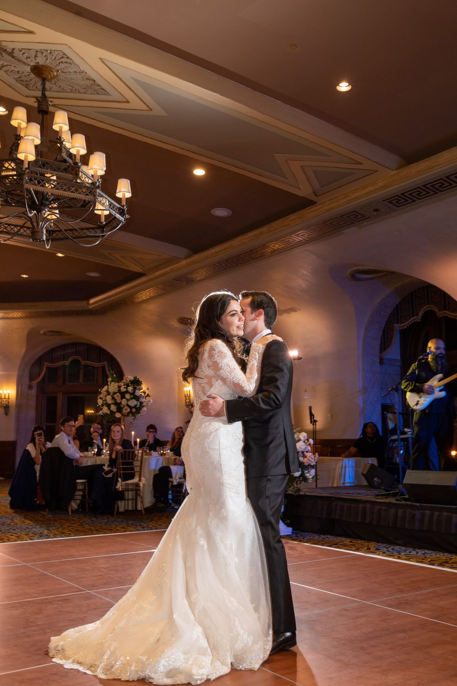 A couple shares their first dance in an elegant Alhambra ballroom with ornate chandeliers at Fairmont Banff Springs Hotel in Banff.