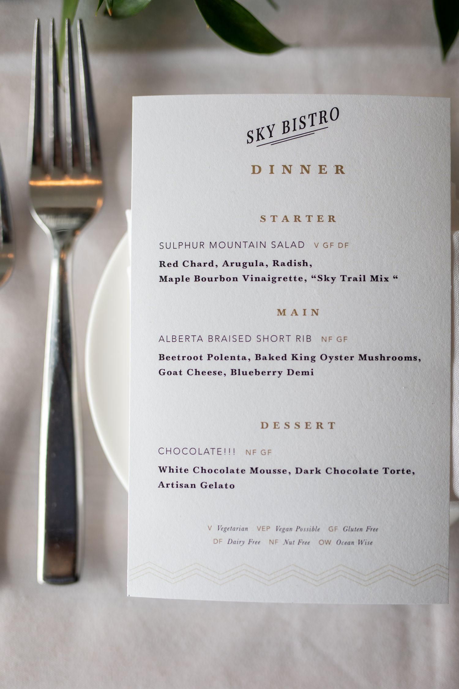 Sky Bistro dinner menu on white plate featuring starter, main, and dessert courses at an elegant table setting.