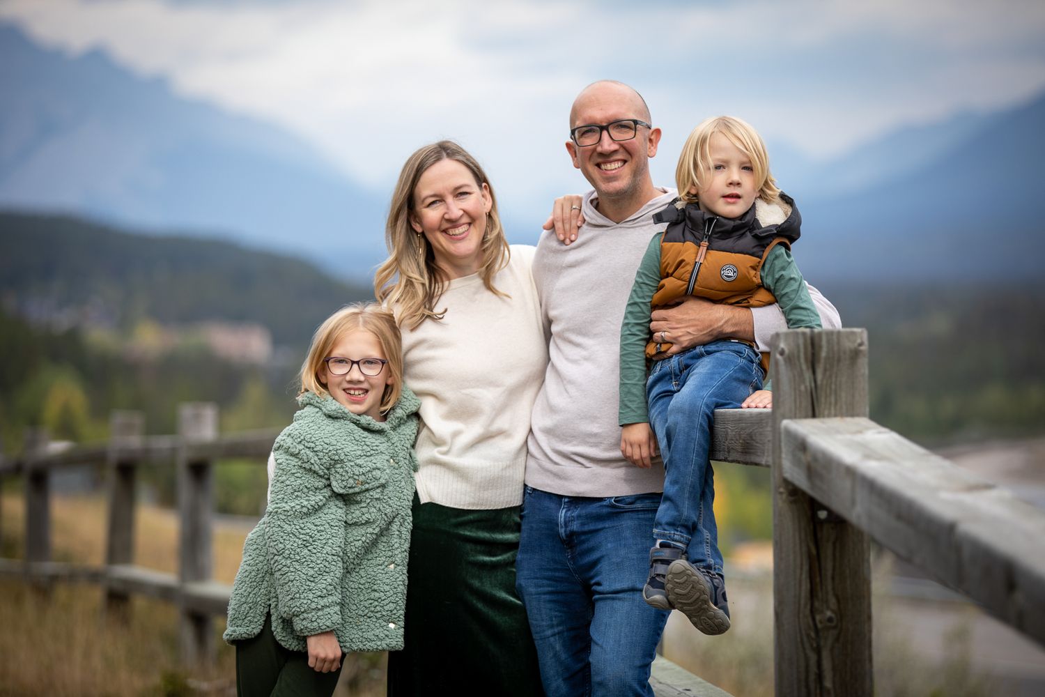 Family enjoying outdoor moments together in casual clothing against mountain backdrop at Quarry Lake Park, Canmore, AB.