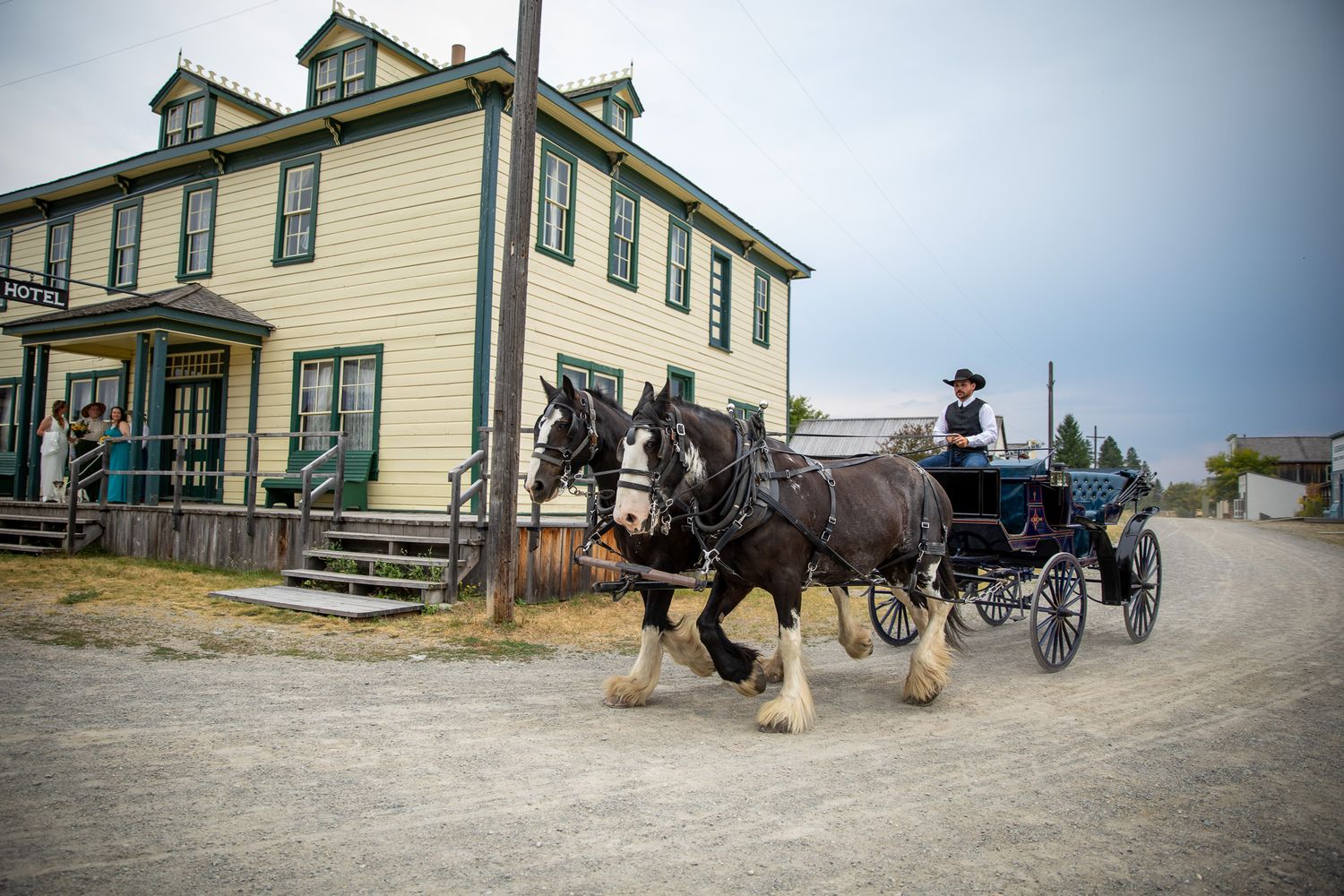 A bride riding a horse carriage to a wedding ceremony site at the heritage Fort Steele, Cranbrook, BC