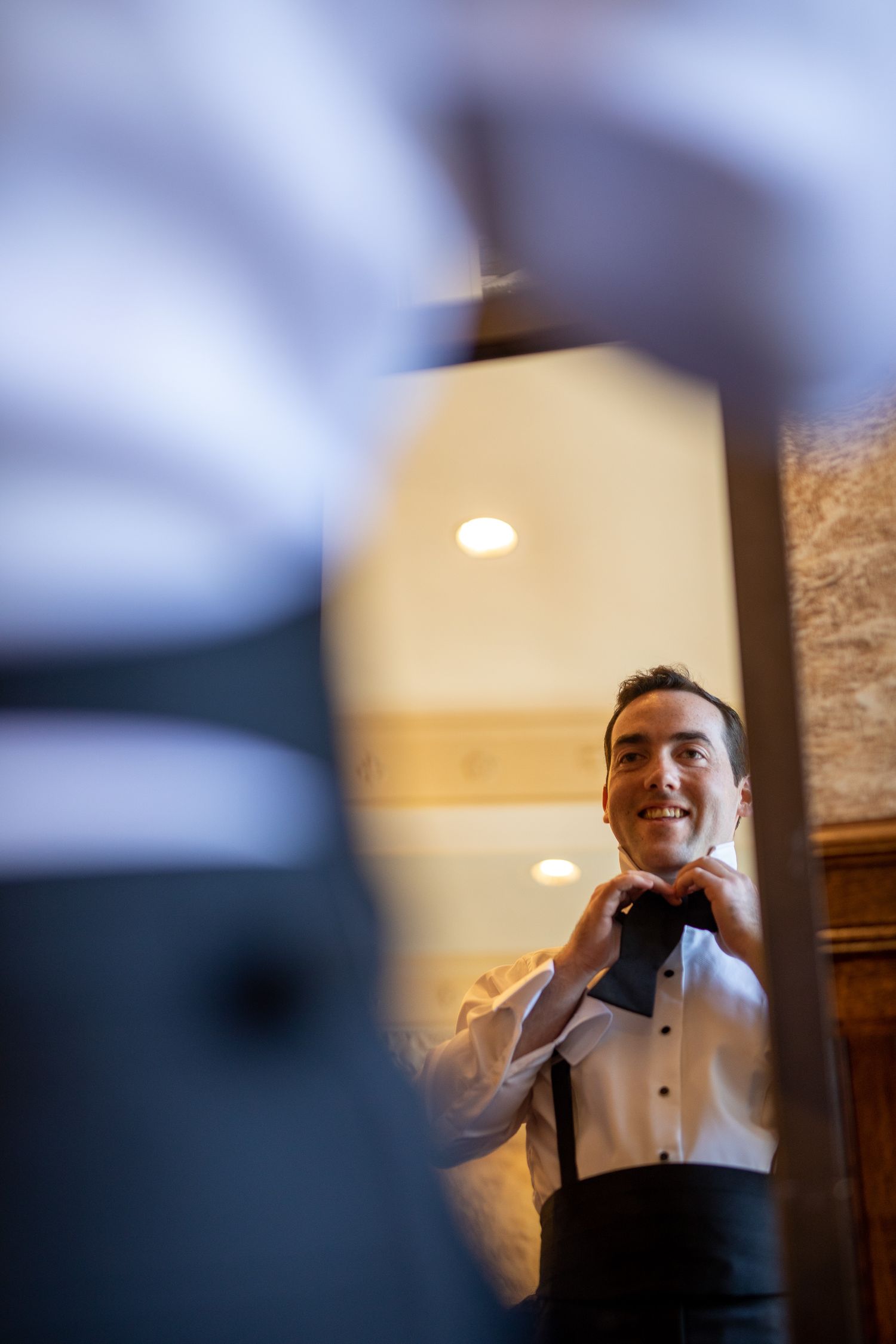A sequence of blurred photos shows someone in formal attire adjusting their bow tie in a dimly lit room. Fairmont Banff Springs Hotel