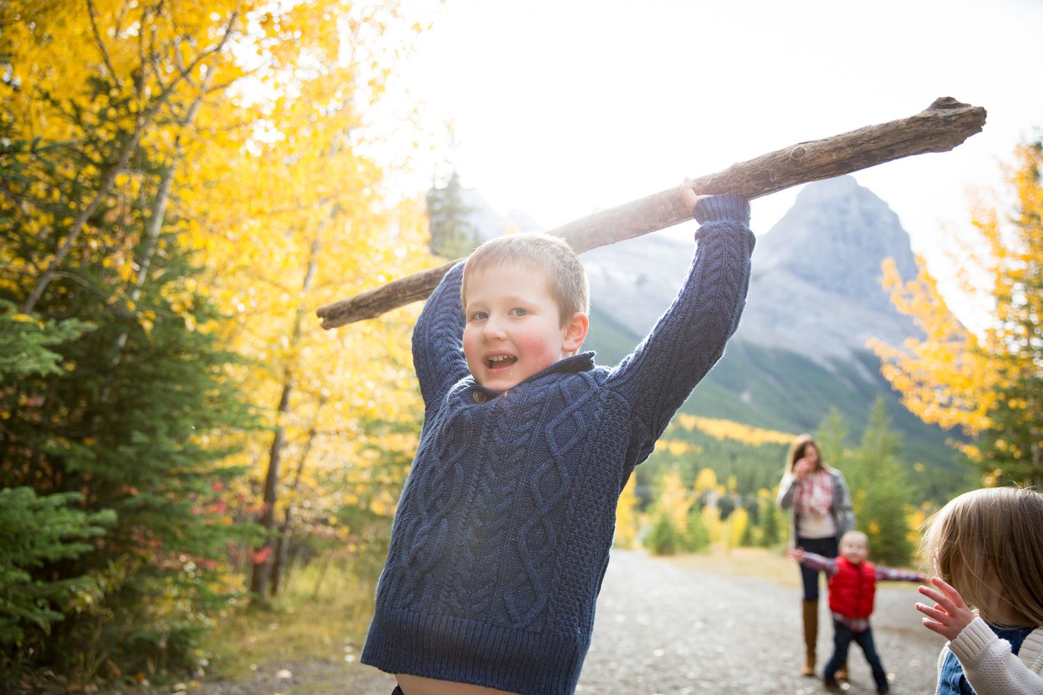 A group of people playing and running together in a park during autumn with golden yellow leaves in the background at Quarry Lake Park, Canm