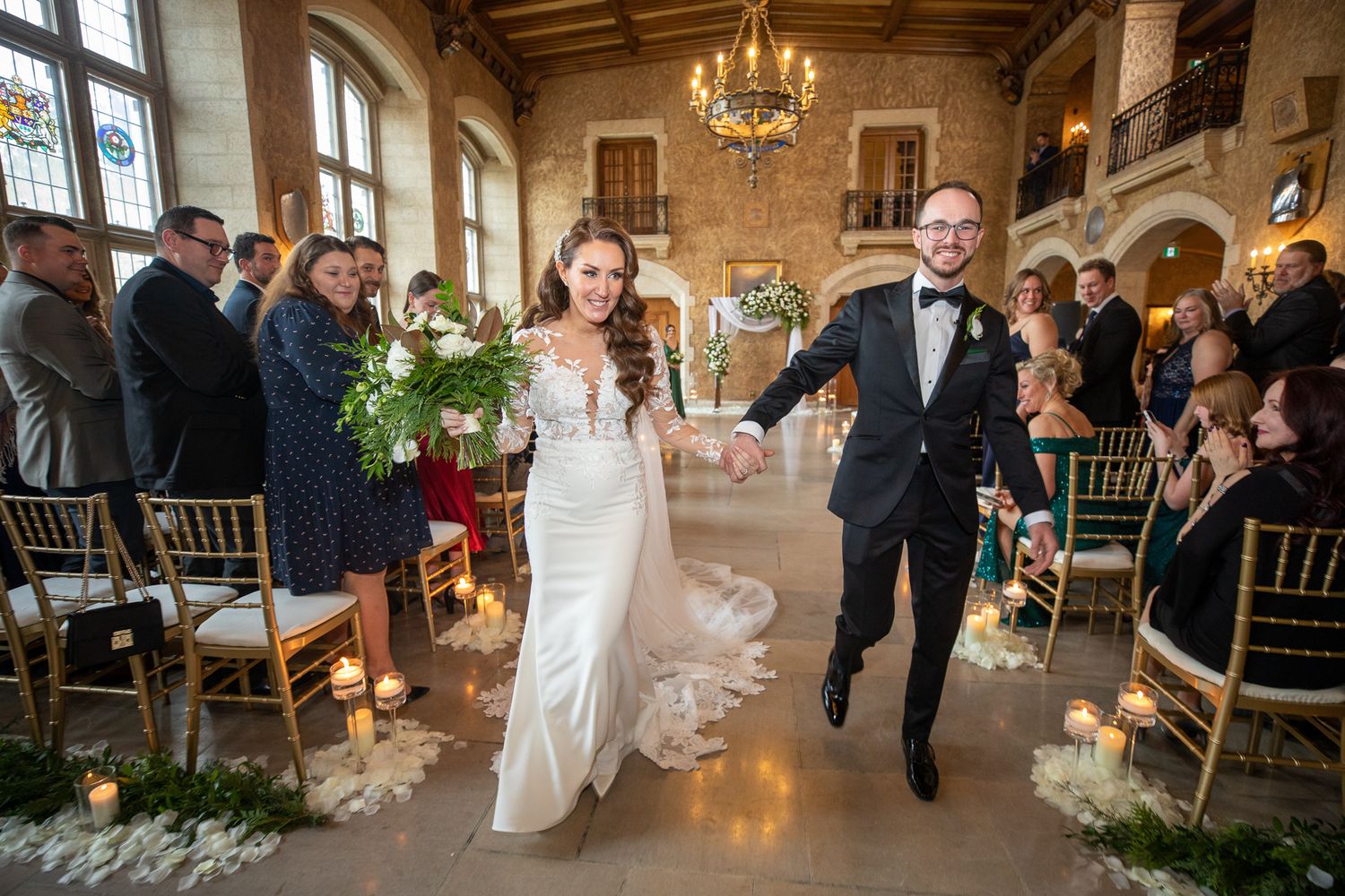 Wedding reception guests dancing and celebrating in an elegant ballroom with chandeliers and wooden beams. Fairmont Banff Springs Hotel, AB.