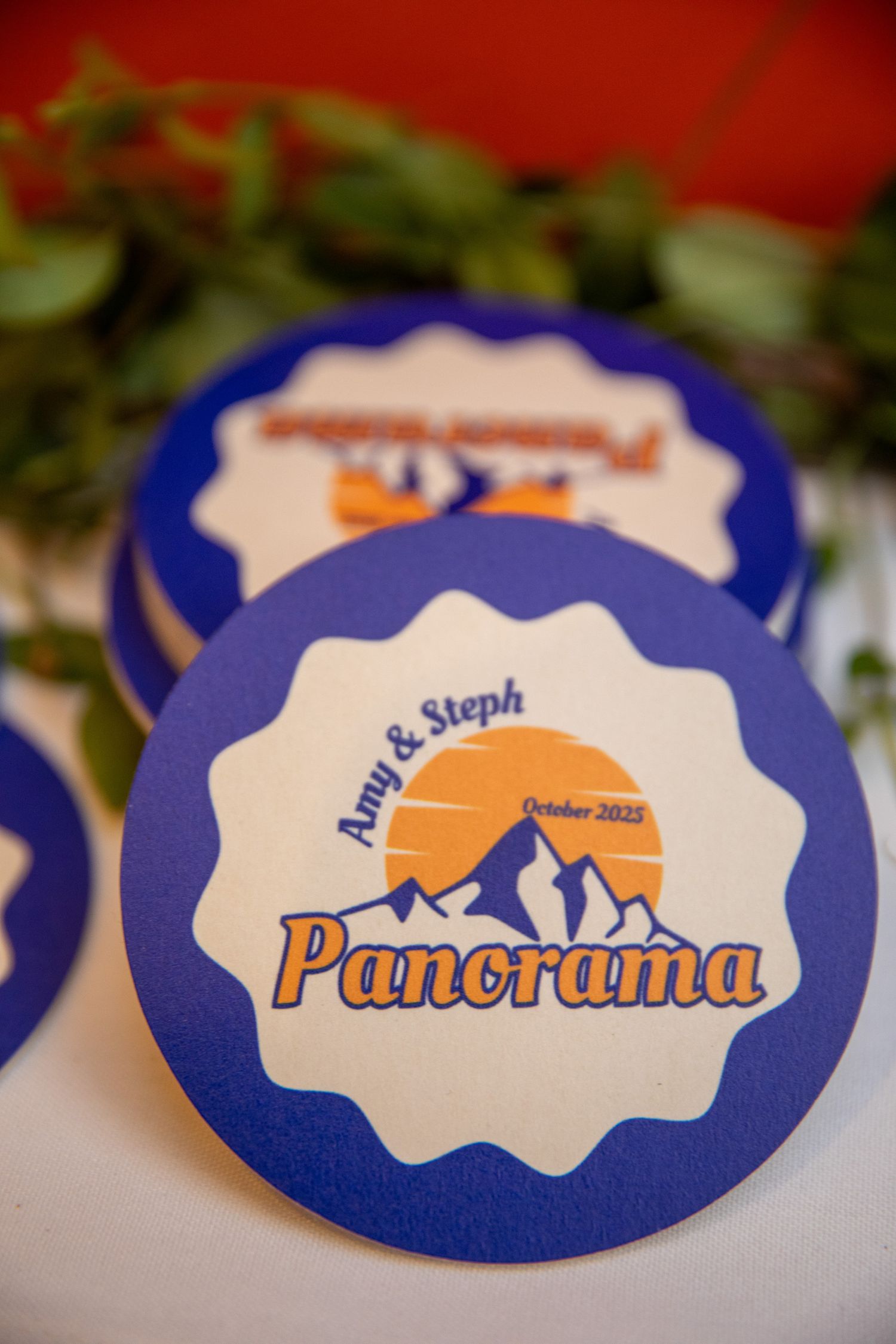 Wedding invitation design detail shows a blue border with orange text and graphics in a panoramic style.