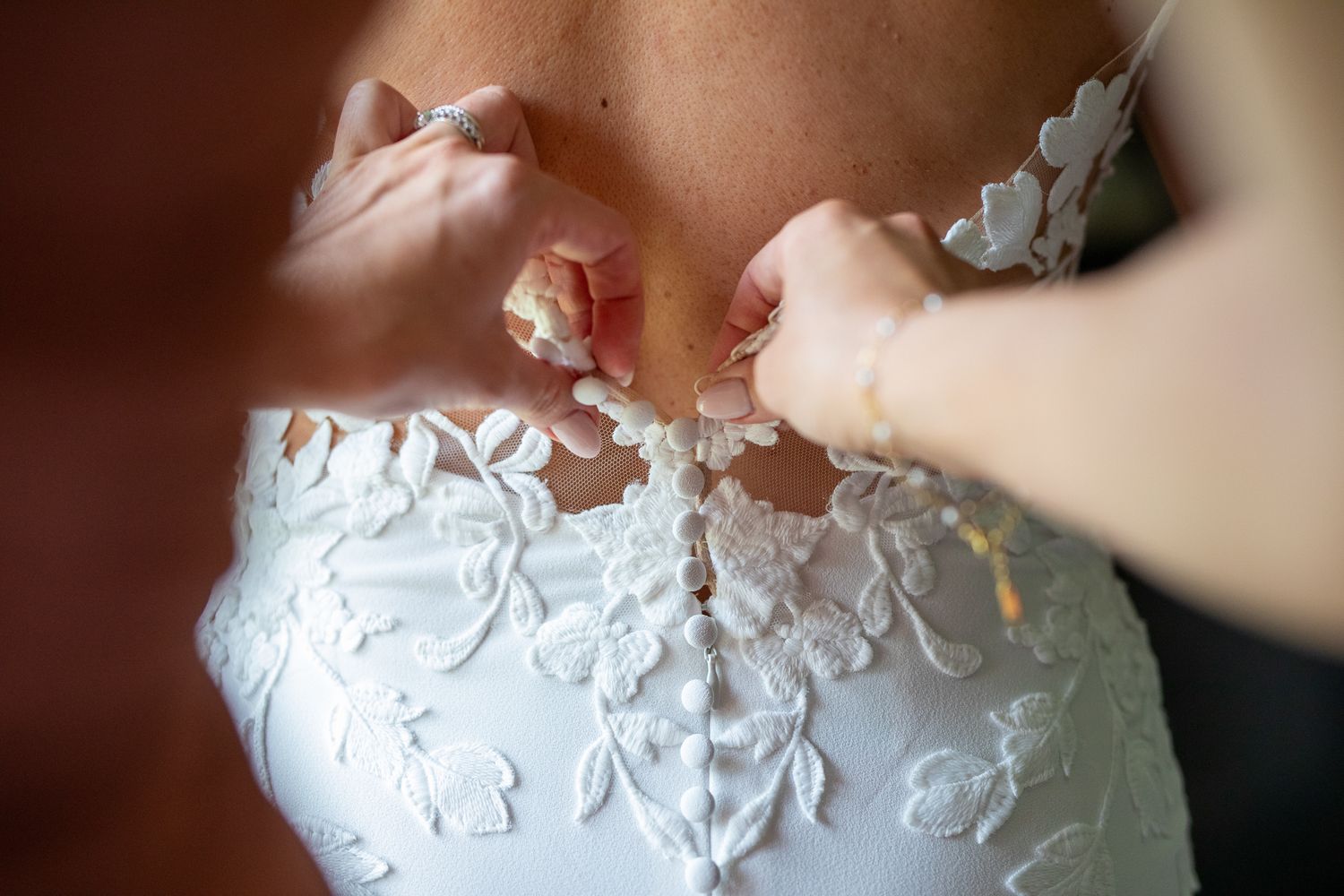 Close-up view of intricate white lace and beading details on a wedding dress. Tunnel Mountain Reservoir Banff, AB