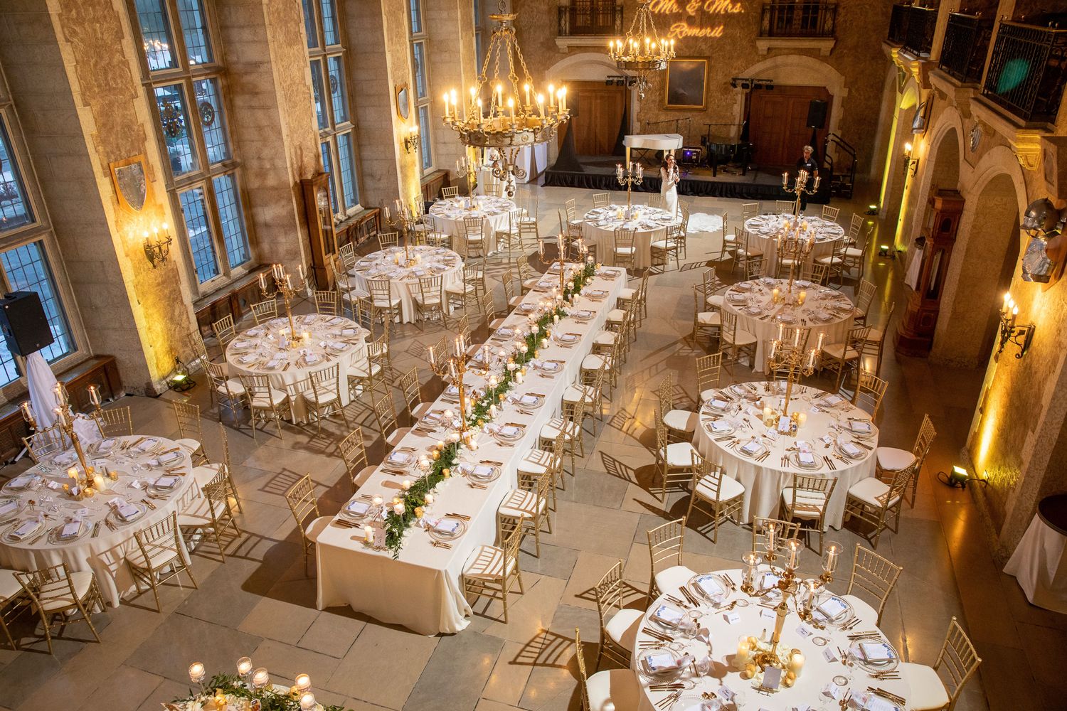 Elegant ballroom wedding reception with crystal chandeliers, round tables, and gold accents throughout the space. Fairmont Banff Springs