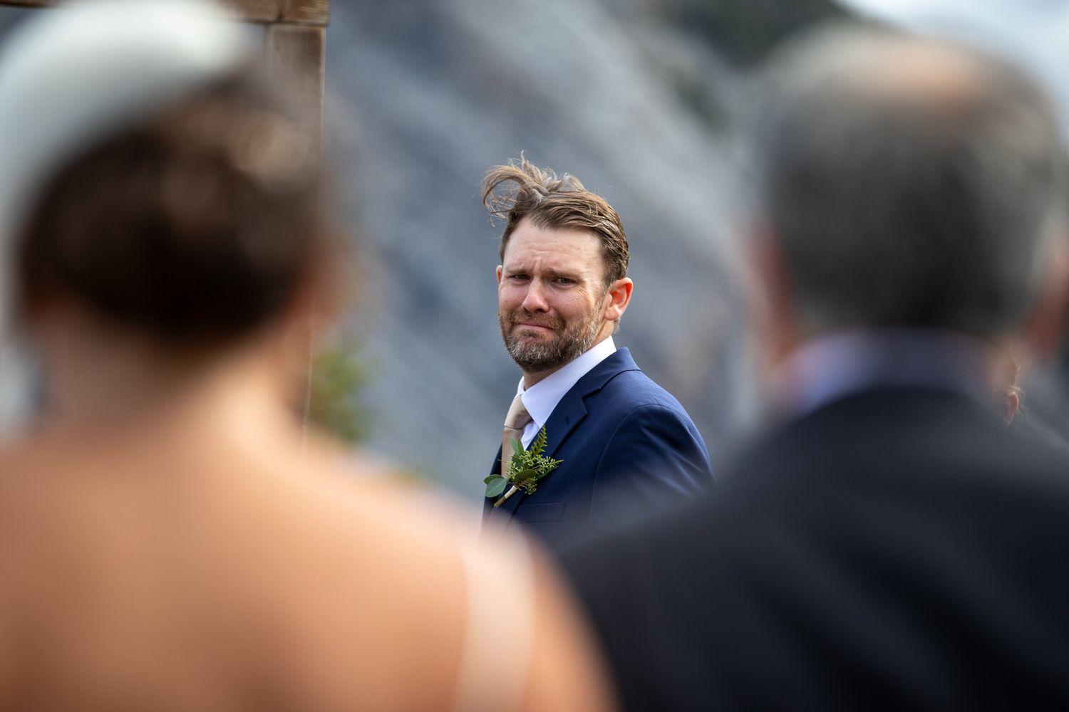 A groom in a dark suit break in tears when a bride walk down the aisle. Tunnel Mountain Reservoir Banff, AB