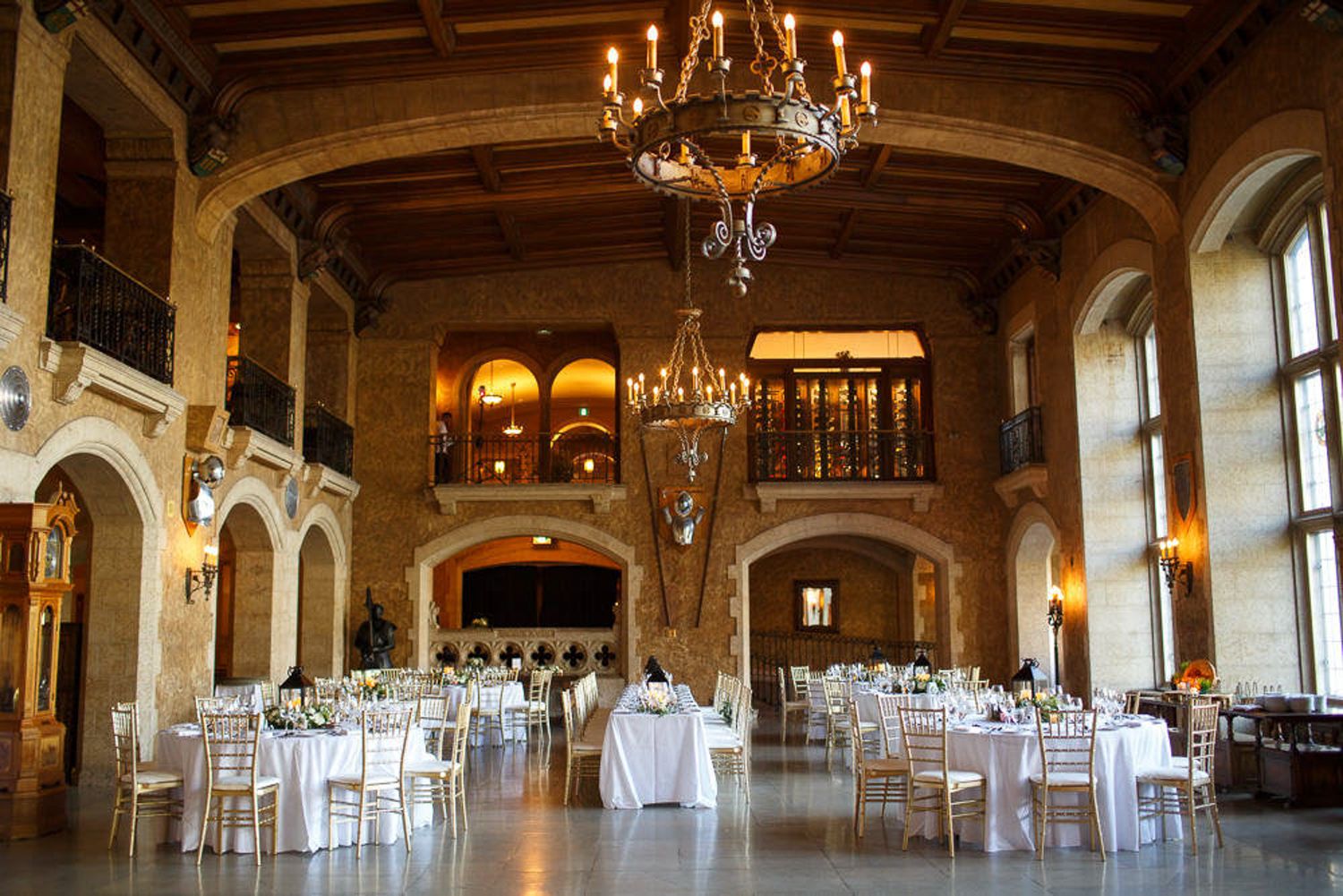 Elegant ballroom with crystal chandeliers, arched windows, and white chairs arranged for a formal event. Fairmont Banff springs hotel. Banff