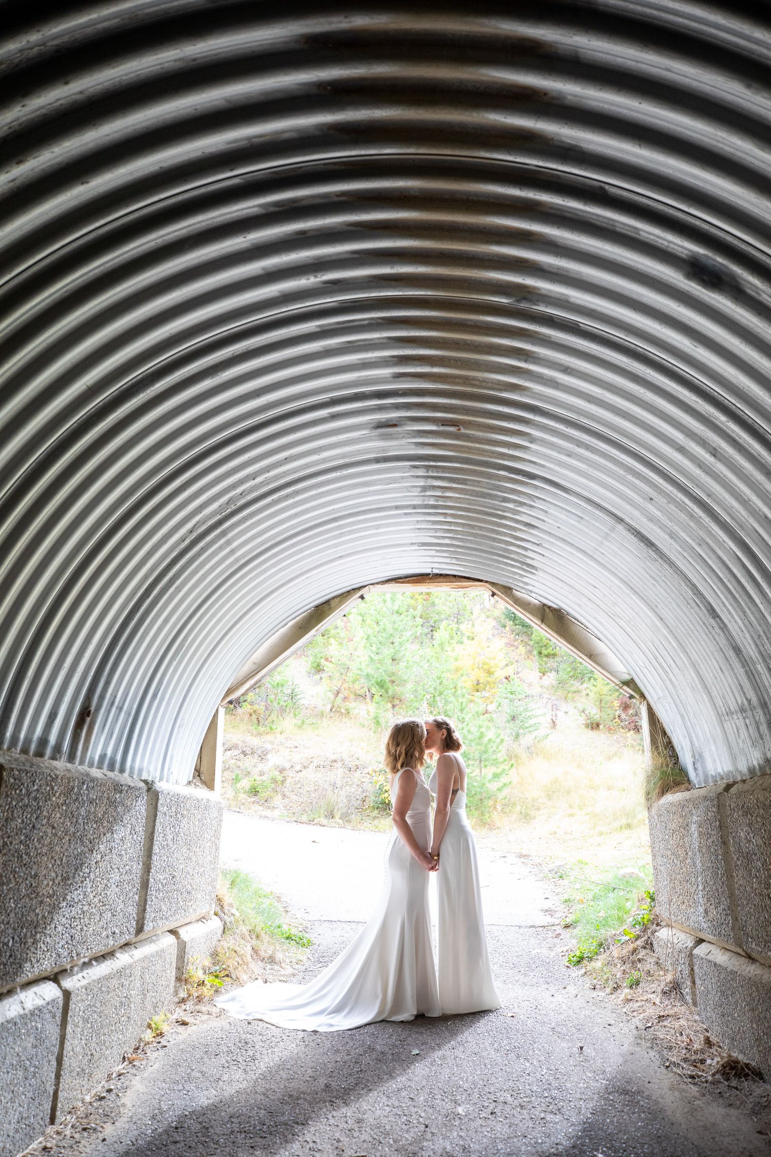 A series of wedding photos taken in a curved tunnel showing a couple silhouetted against natural light at the tunnel exit. Earl Grey Lodge