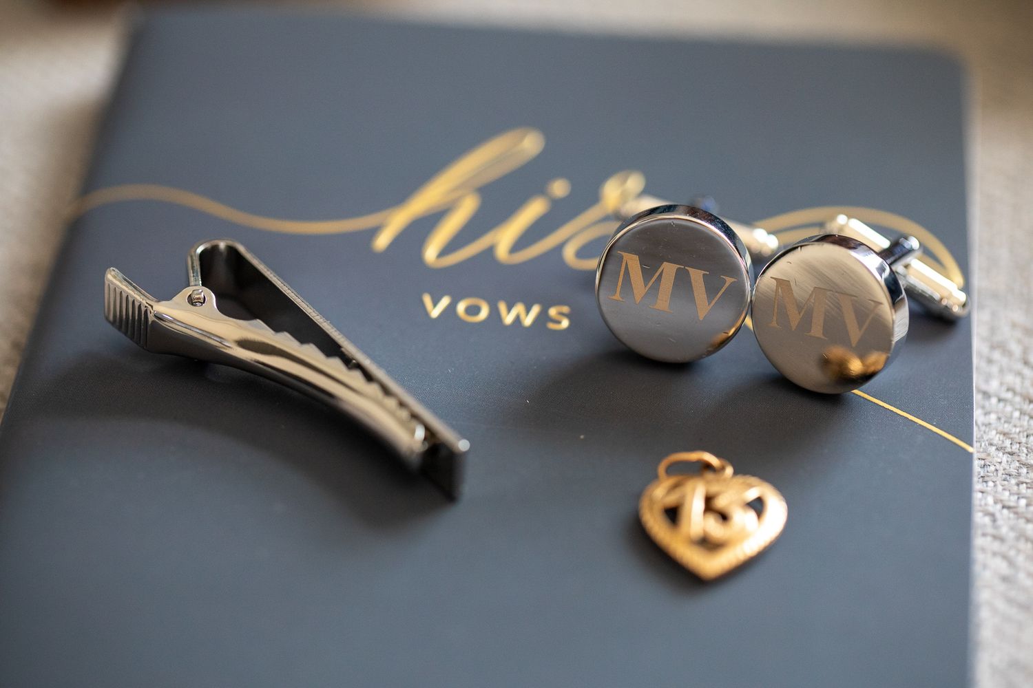 A close-up view of silver keys with a heart-shaped charm keychain on a dark background.