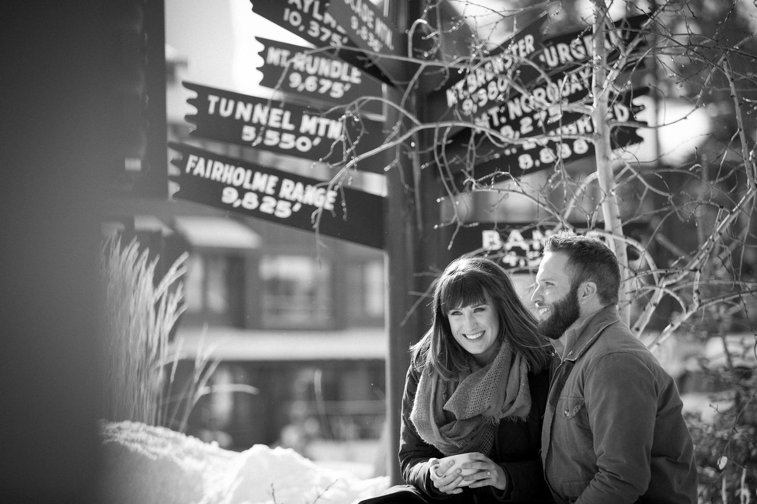 A black and white photograph shows two people smiling together outside at Whitebark cafe in Banff, AB.