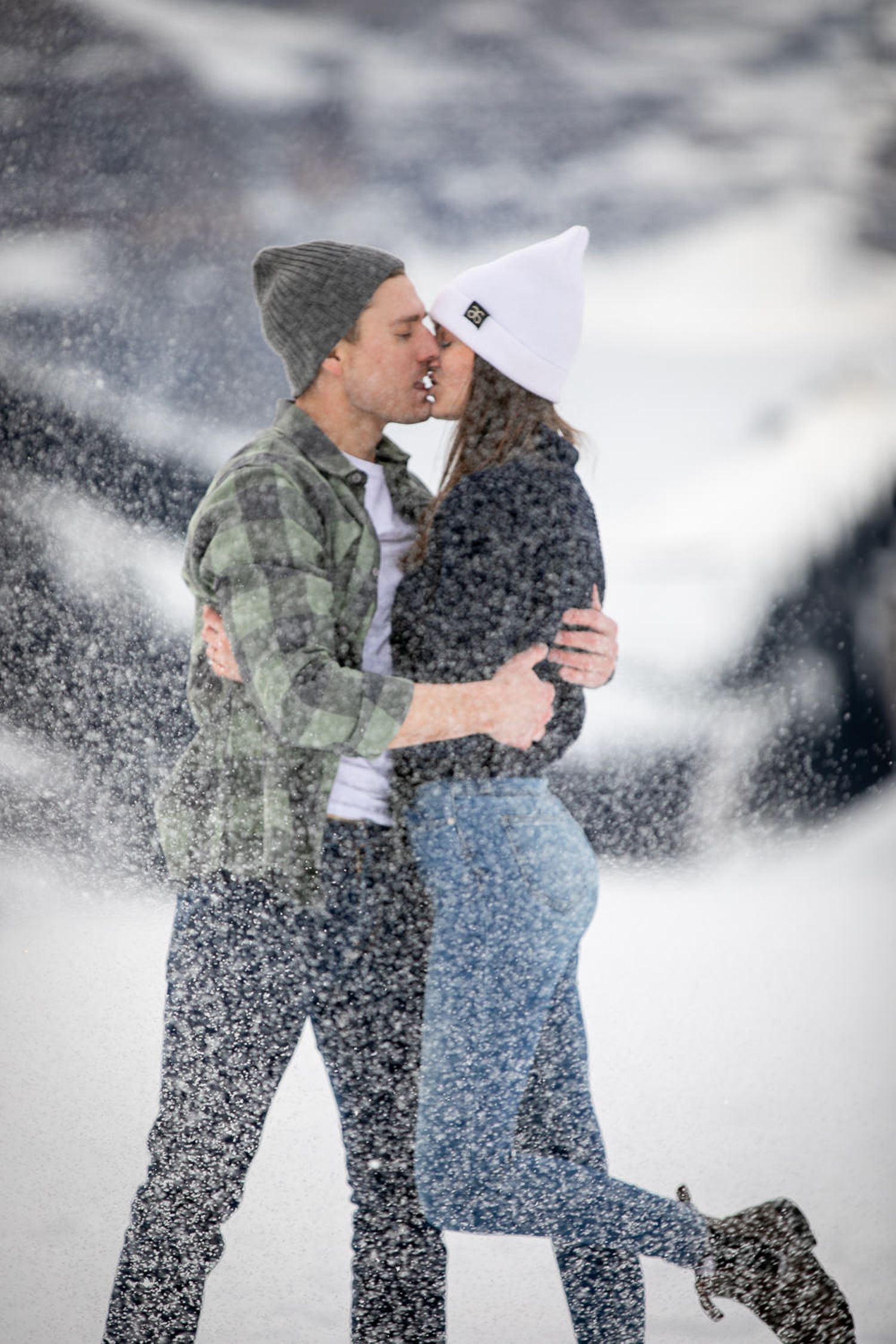 A couple embraces in the snow during a romantic winter photo session in the mountains at Lake Louise in the Canadian Rockies.