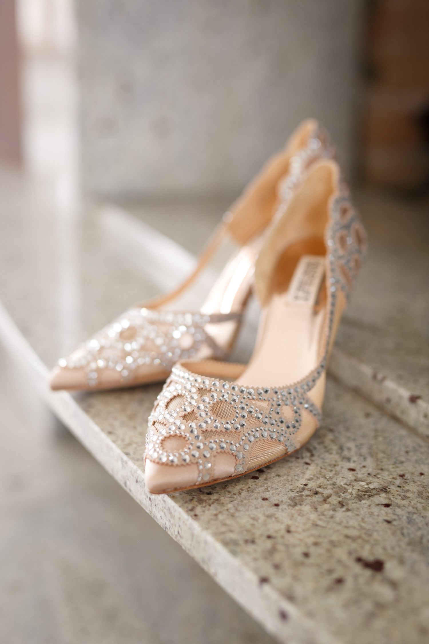 Elegant blush pink Badgley Mischka bridal heels adorned with intricate crystal embellishments displayed on marble steps. Cherry creek estate