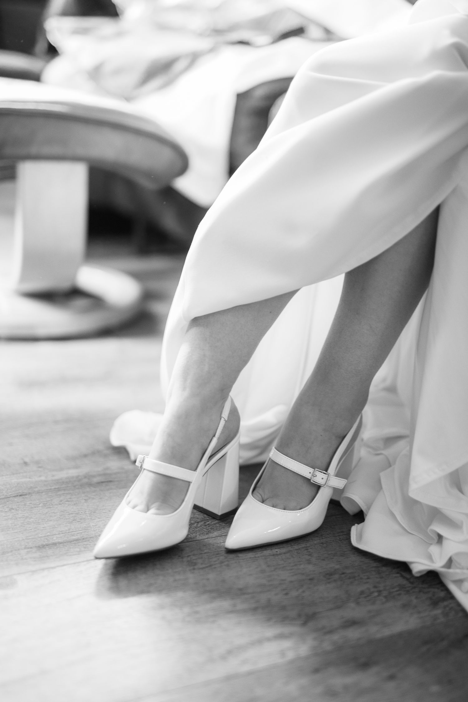 Close-up view of white wedding shoes and dress hems in a series of black and white photographs. Earl Grey Lodge, BC
