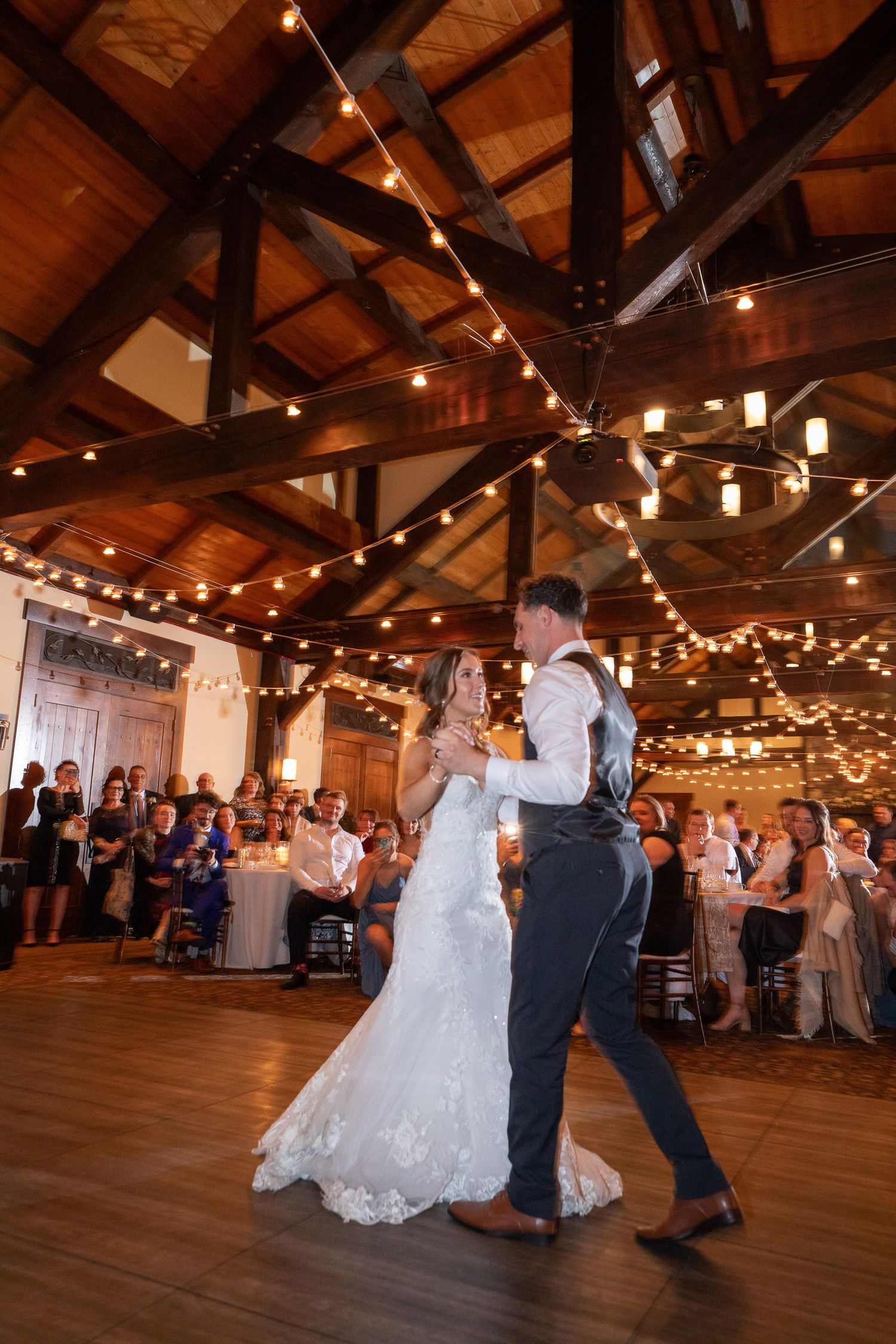 A couple shares their first dance at the Pavilion room in low evening lights at Silvertip wedding venue in Canmore, Alberta.
