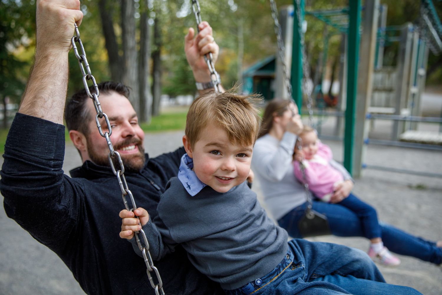 Four sequential photos showing someone swinging joyfully on a playground swing set in an urban park setting Timber Ridge in Windermere, BC